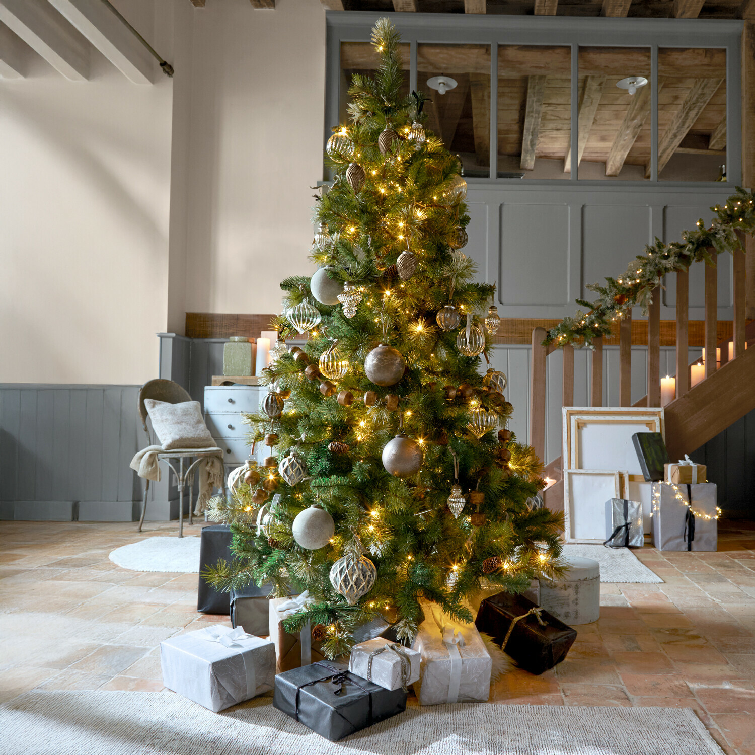 Sapin de Noël Aure Sapin de Noël décoré avec guirlandes lumineuses dorées et cadeaux dans un salon chaleureux