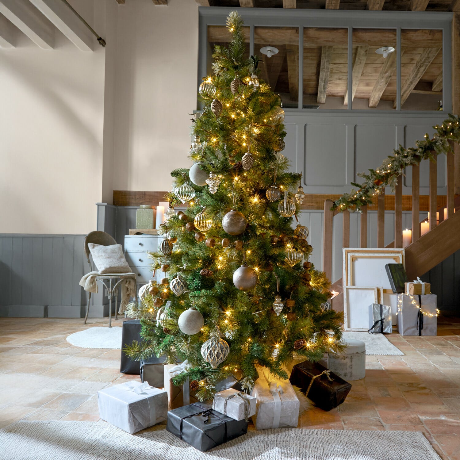 Sapin de Noël Aure Sapin de Noël décoré avec guirlandes lumineuses dorées et cadeaux dans un salon chaleureux