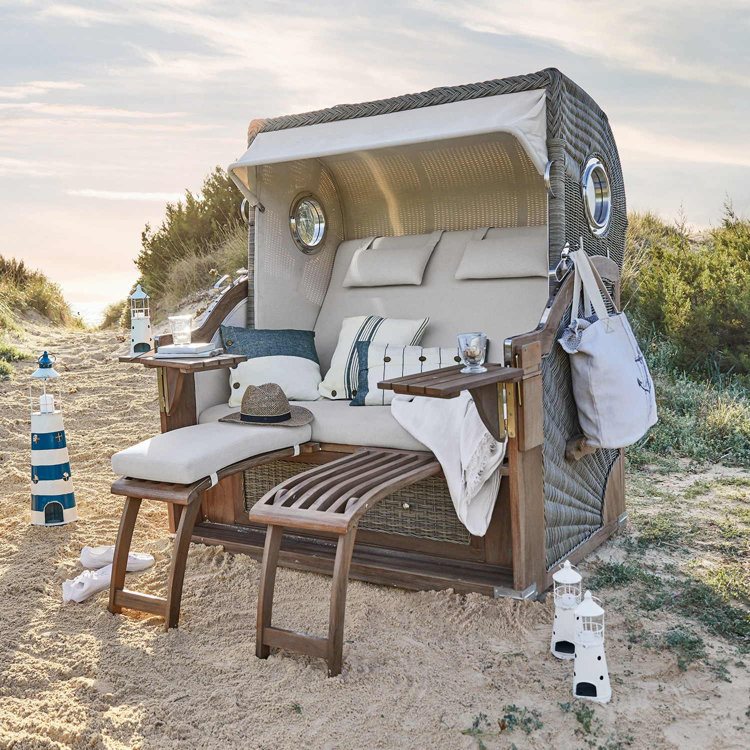 Corbeille de plage Clifford Beach Fauteuil de plage en osier avec coussin beige et repose-pieds en bois sur le sable, mobilier extérieur