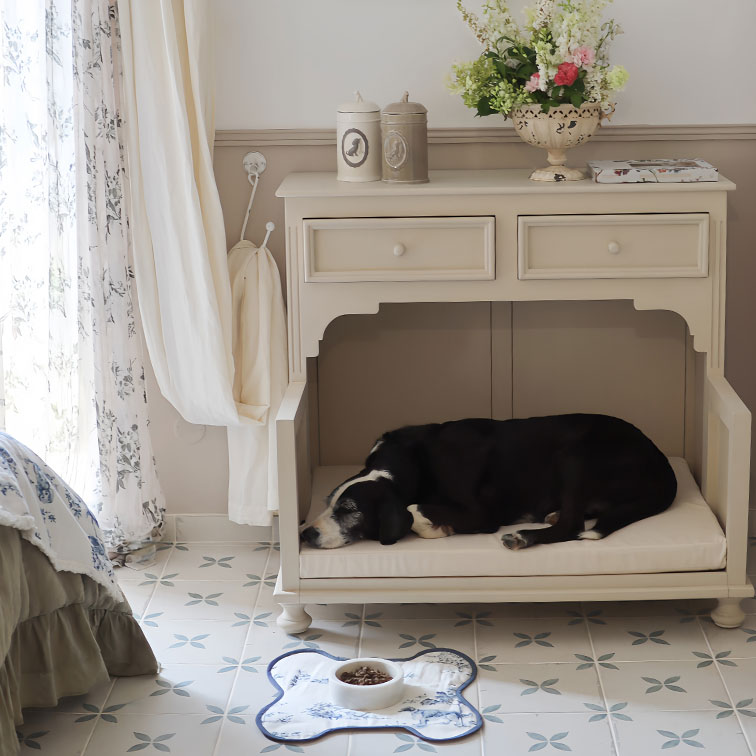 Console en bois beige avec coussin pour chien, décorée de boîtes et vase fleuri dans une pièce lumineuse