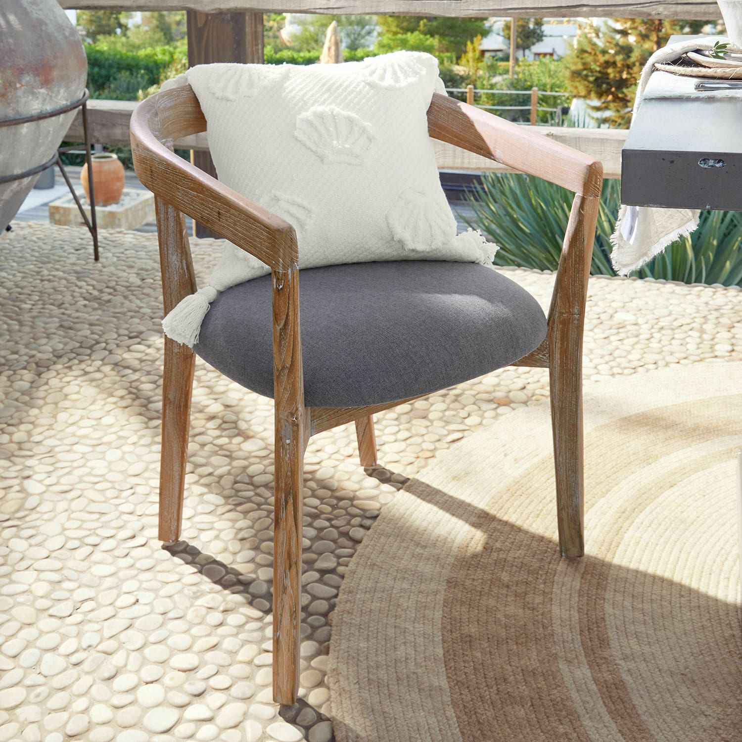 Chaise Lunebois Chaise en bois avec assise grise et coussin décoratif blanc sur terrasse ensoleillée