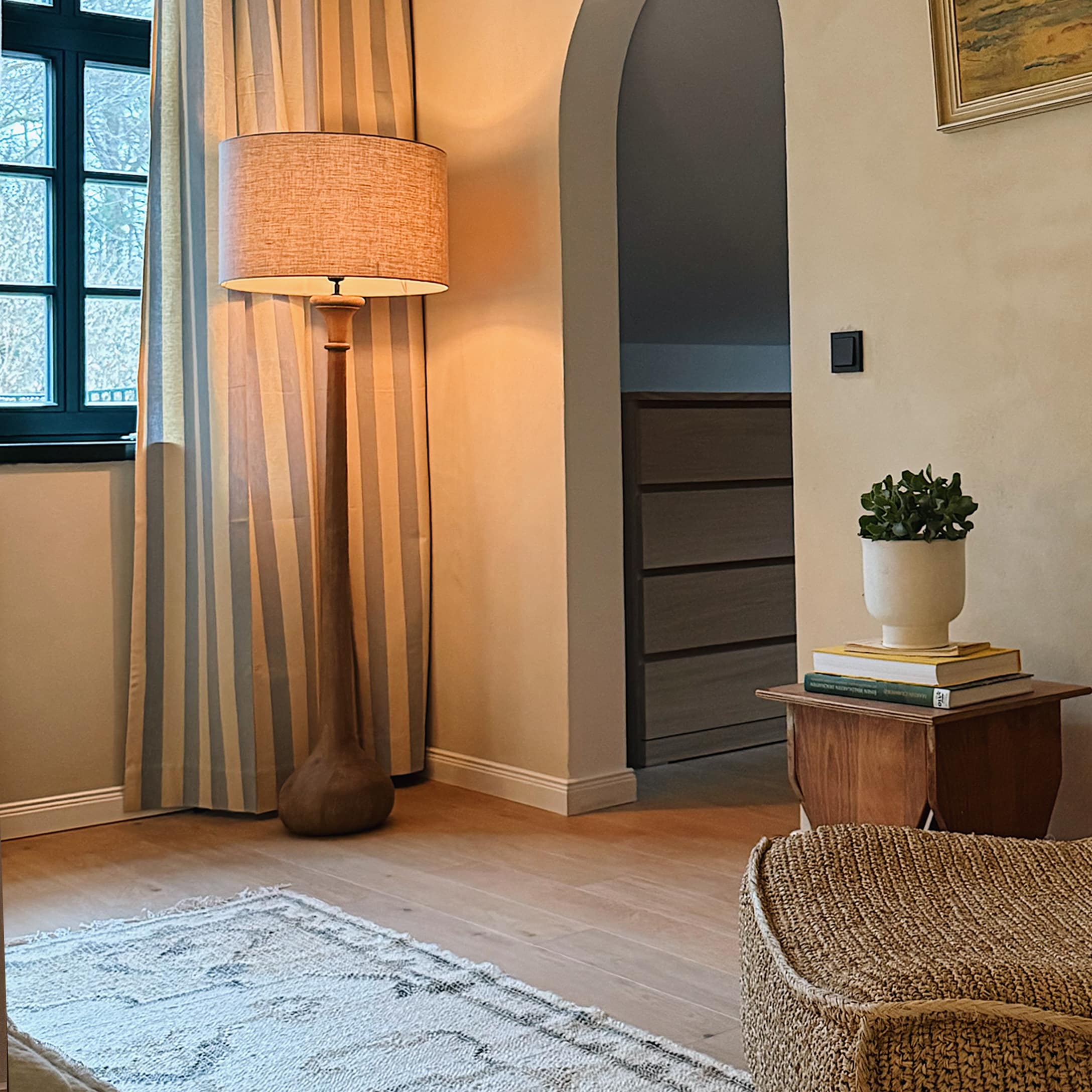 Lampadaire en bois avec abat-jour beige dans un salon chaleureux aux accents naturels