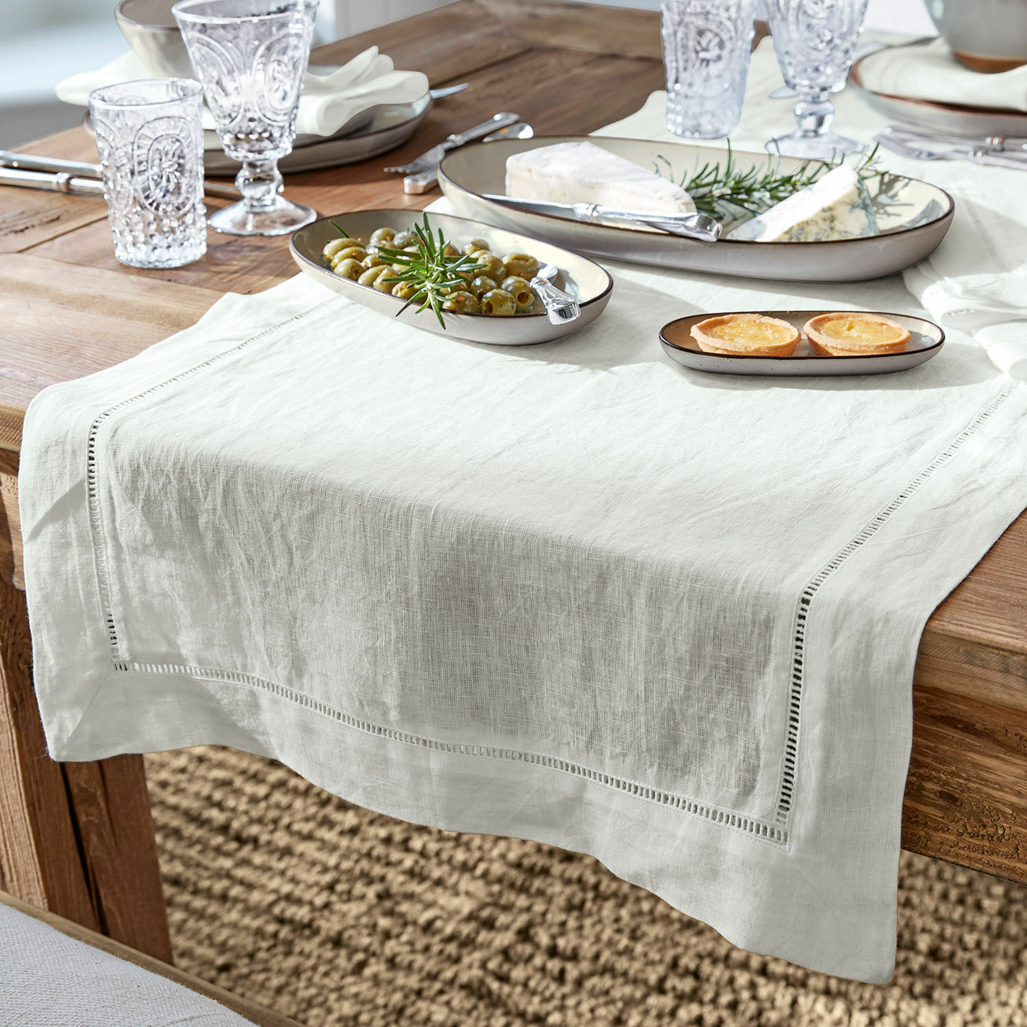 Chemin de table Covent Garden Nappe en lin blanc sur table en bois avec assiettes et amuse-bouches, décoration de table élégante