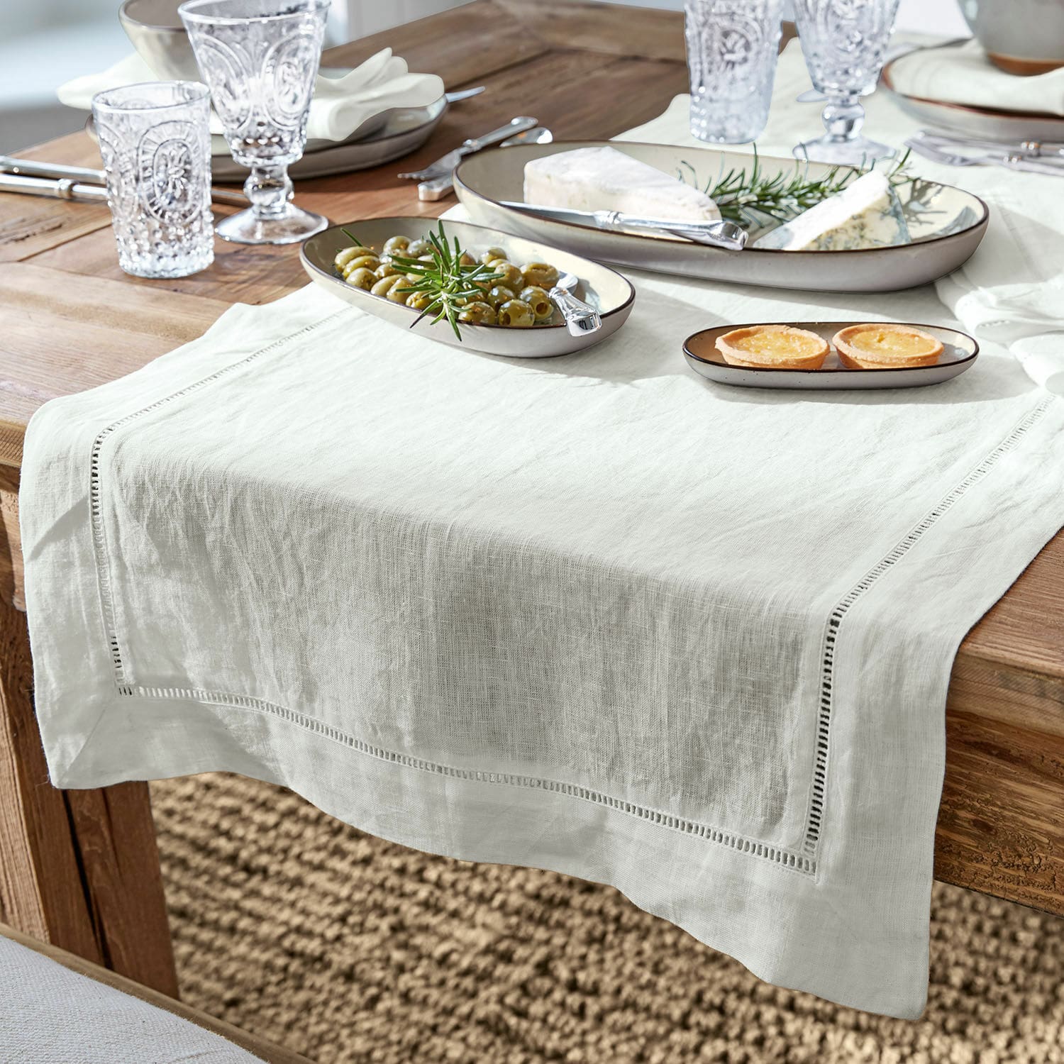 Chemin de table Covent Garden Nappe en lin blanc sur table en bois avec assiettes et amuse-bouches, décoration de table élégante