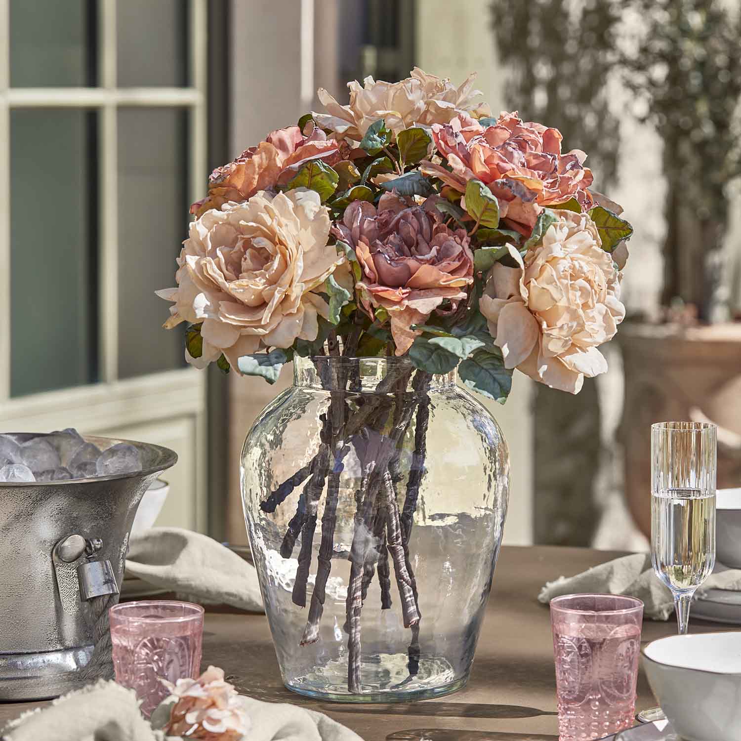 Bouquet de roses dans un vase en verre sur une table, décoration florale aux tons pastel