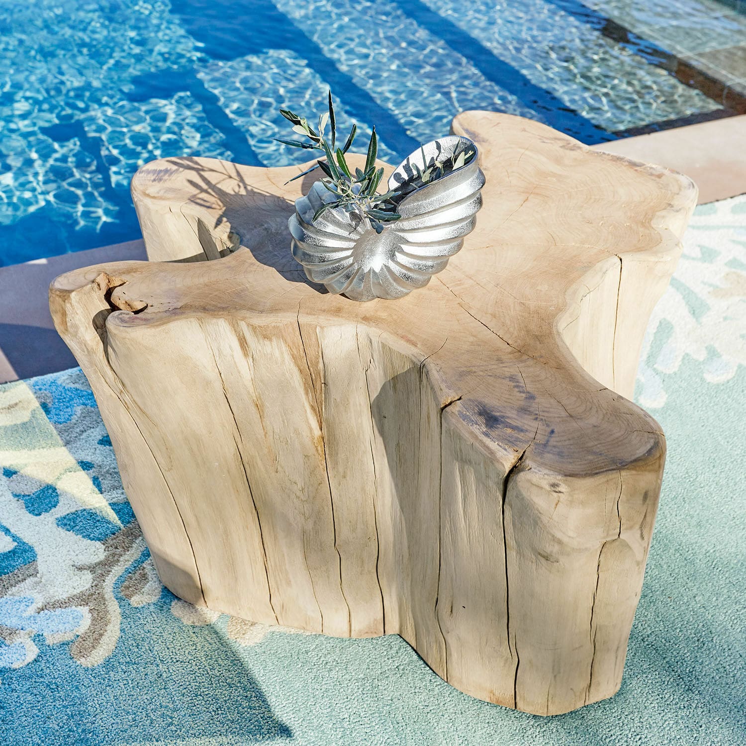 Table basse Dorlancourt Table en bois massif à forme naturelle près d'une piscine avec décoration métallique argentée