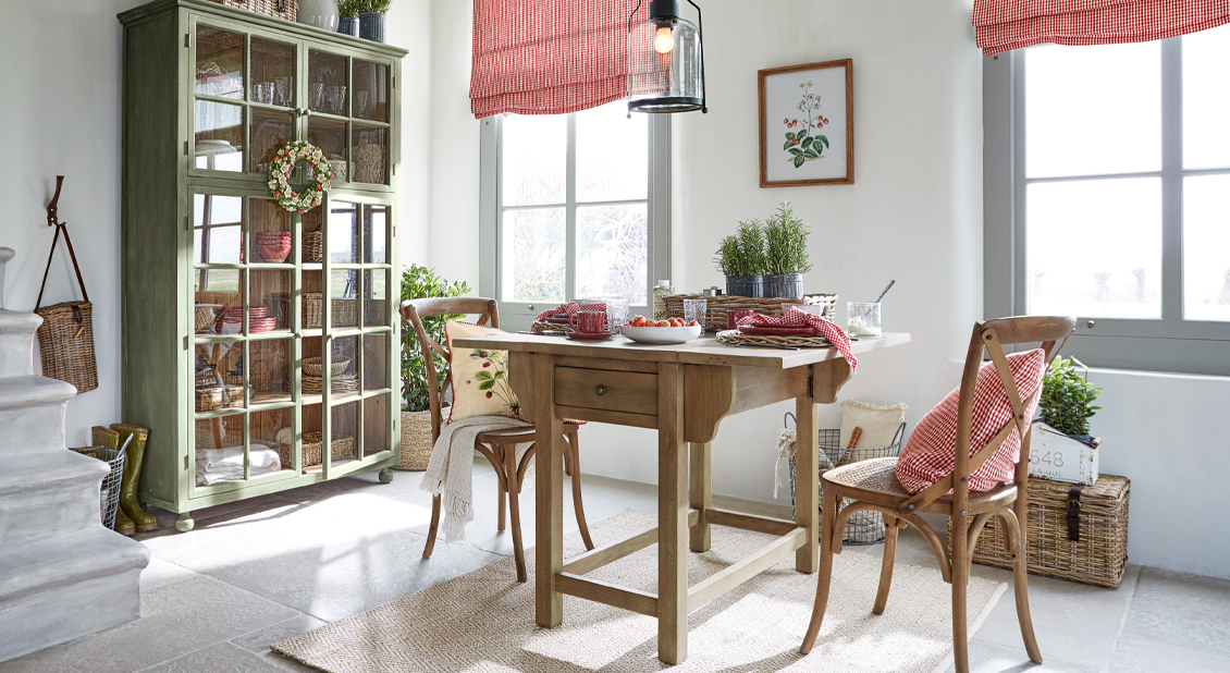Salle à manger campagne avec table en bois, chaises et vitrine verte pour vaisselle