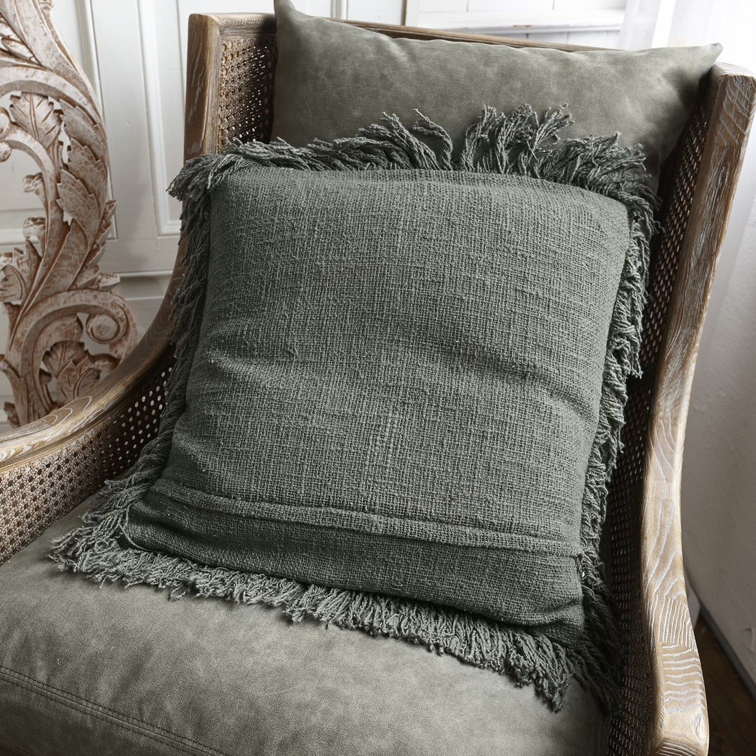 Coussin Greenly Coussin vert avec franges sur fauteuil en bois et rotin pour décoration intérieure