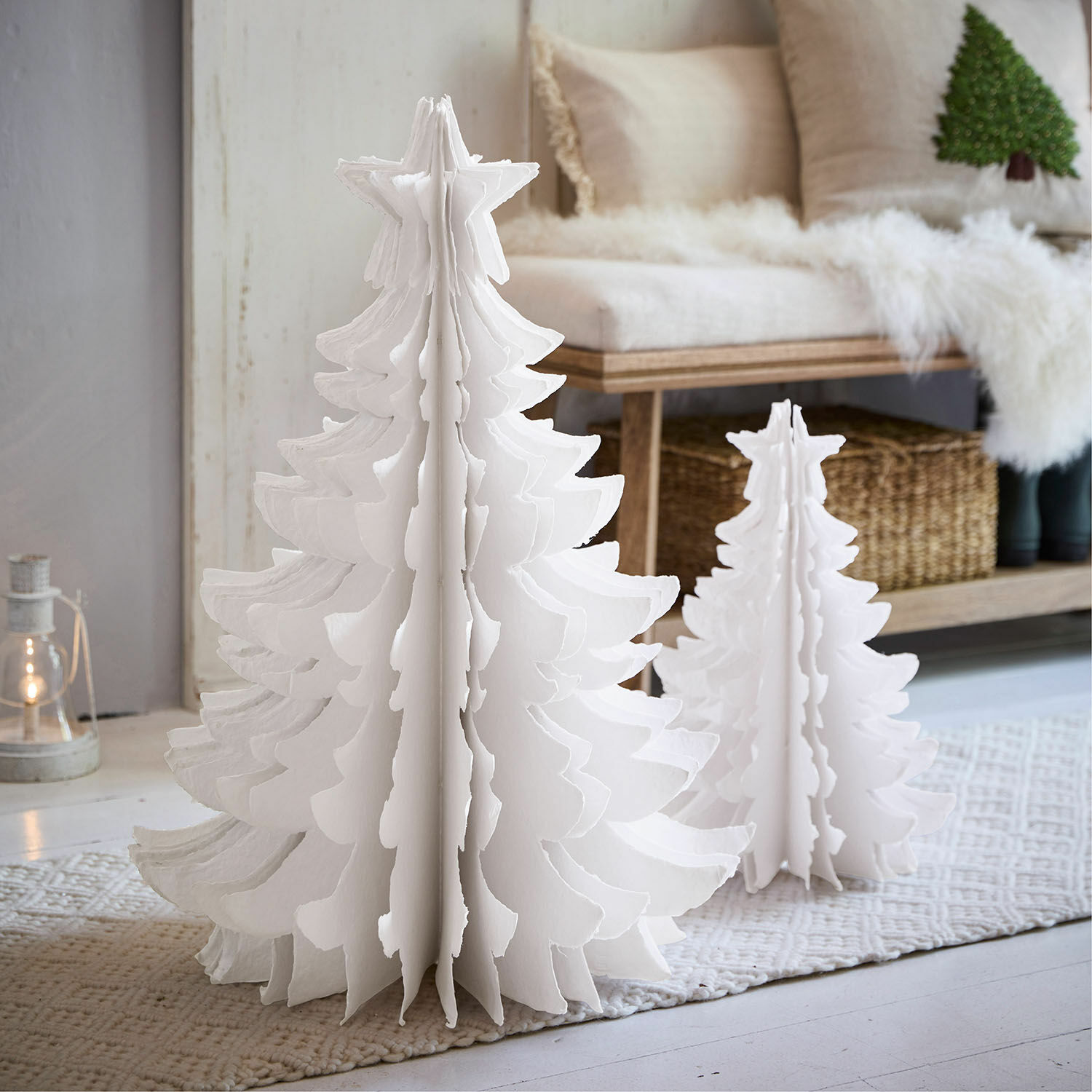 Lot de 2 arbres décoratifs Amuré Deux sapins décoratifs en papier blanc de tailles différentes sur un tapis dans un intérieur clair