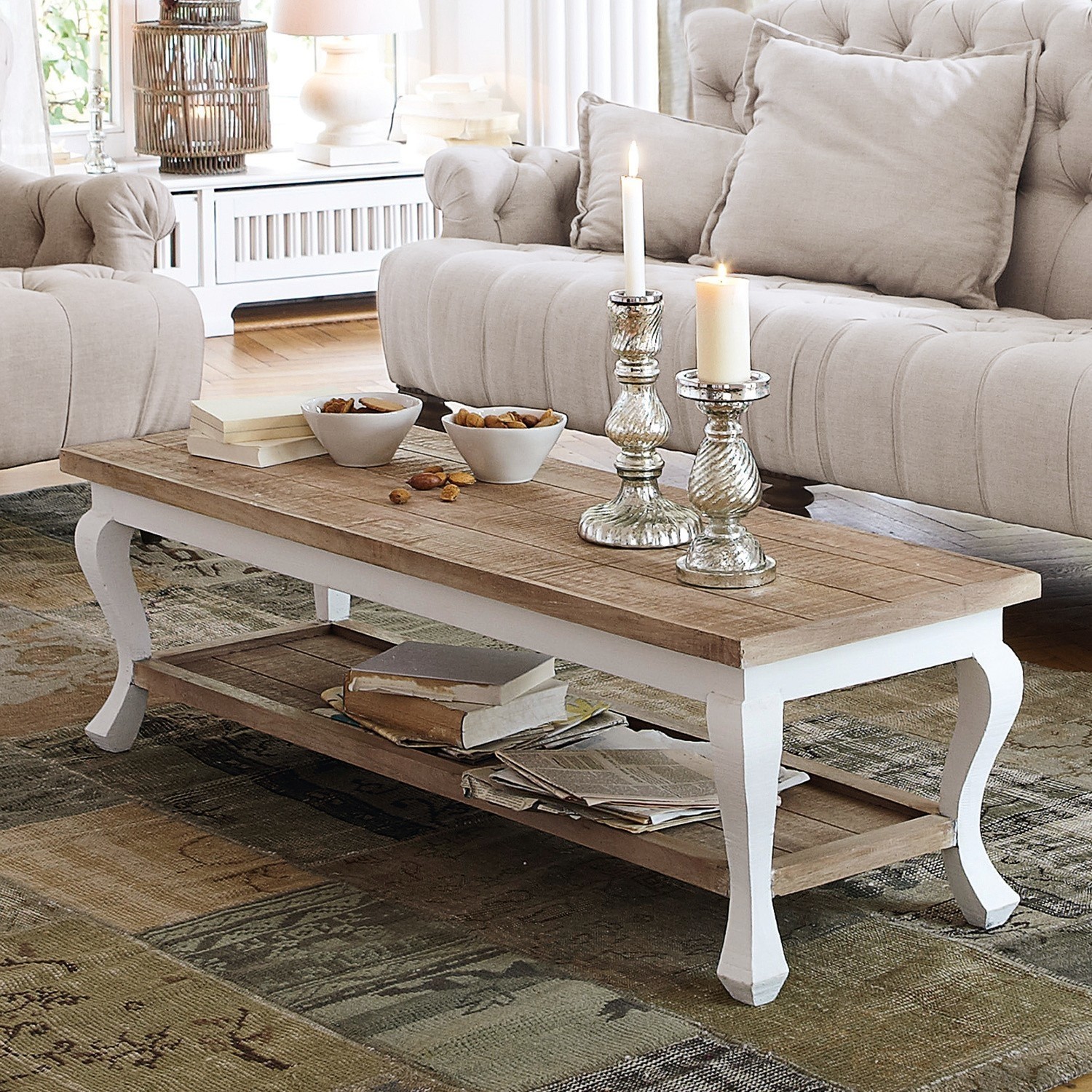 Table basse Riverside Table basse en bois avec pieds blancs sur tapis, livres et bougies, ambiance vintage cosy