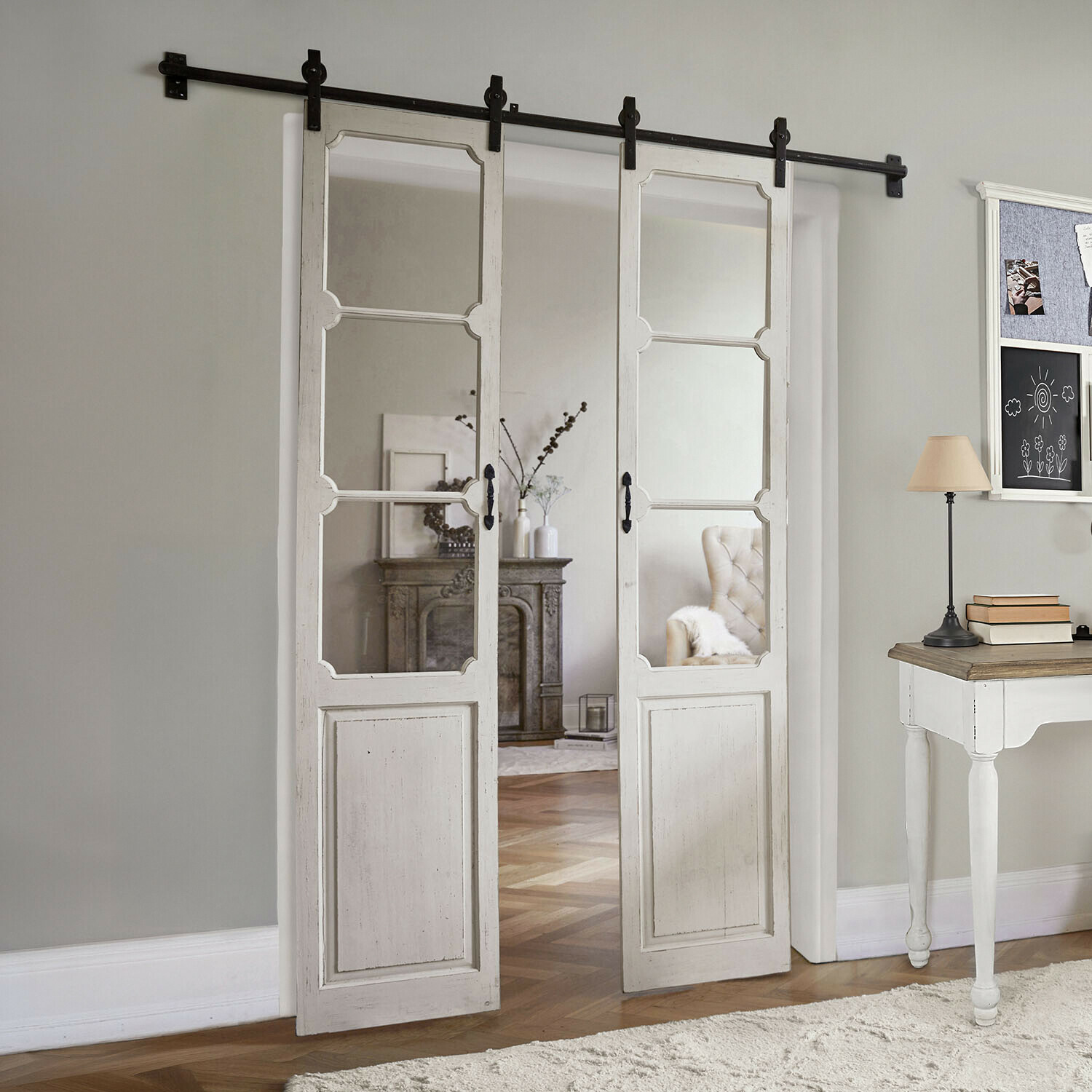 Double porte coulissante Tibout Porte coulissante en bois blanc avec miroir style vintage dans un salon décoré avec bureau et lampe