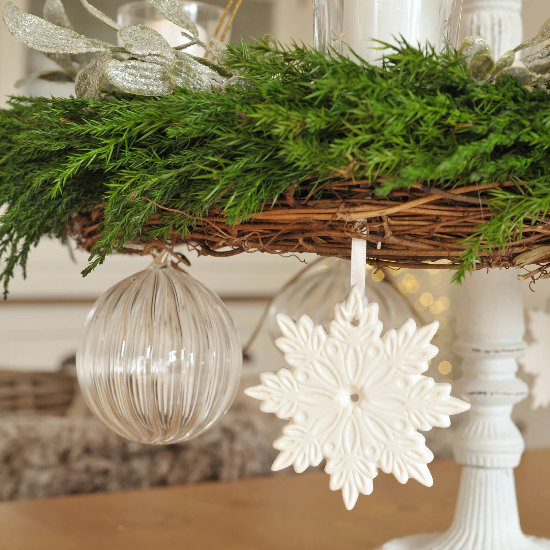 Ornement flocon de neige en céramique blanche et boule en verre transparent sur couronne de Noël verte