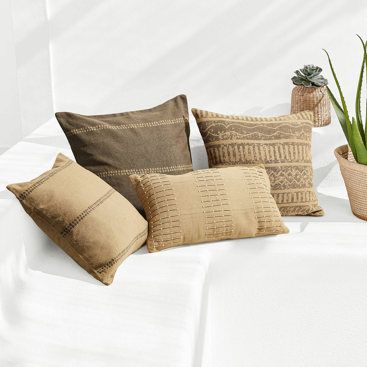 Lot de 4 housses de coussins Patti Ensemble de quatre coussins décoratifs en coton marron avec motifs géométriques pour salon