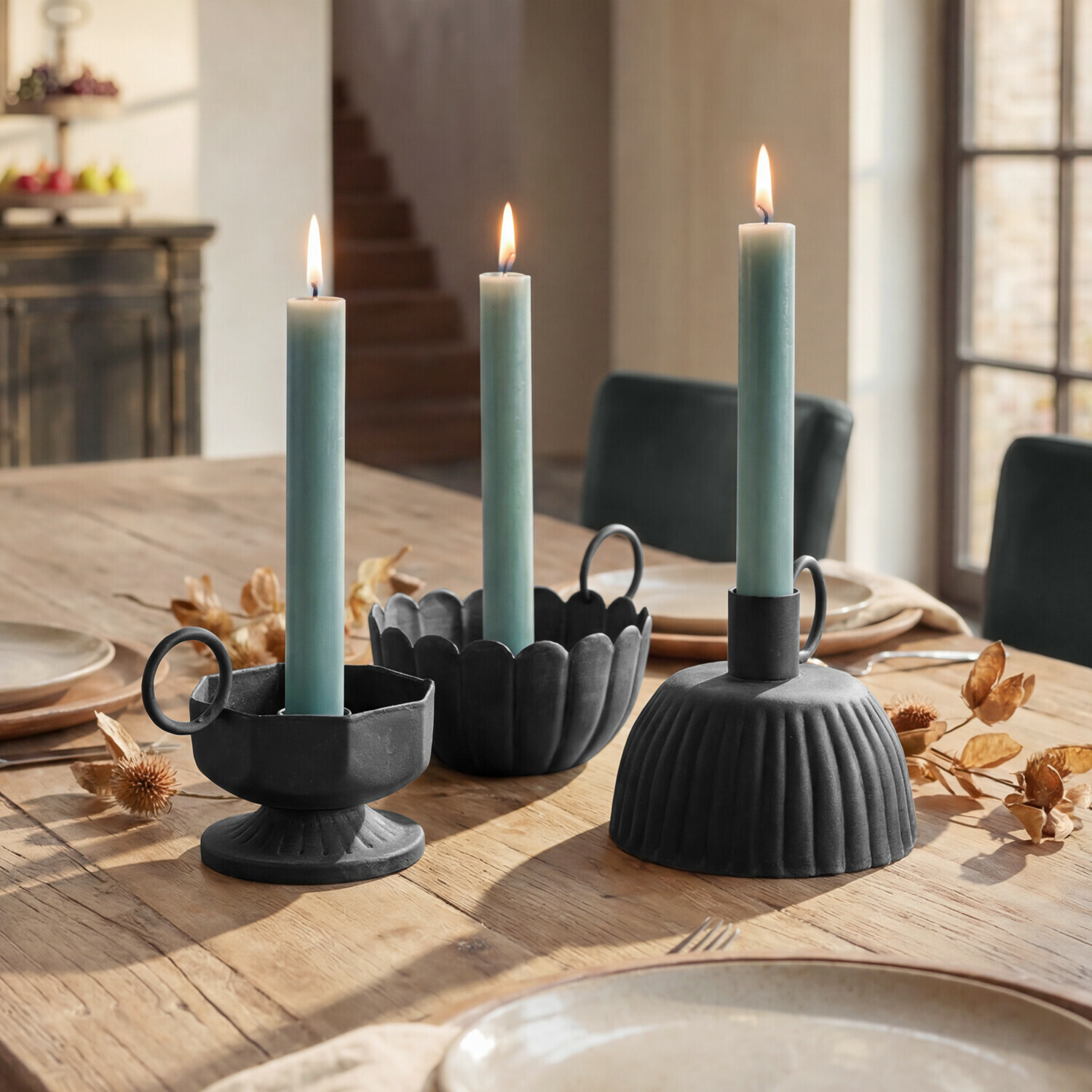 Lot de 3 bougeoirs Lazharin Trois bougeoirs en métal noir avec bougies vertes sur une table en bois dans une salle à manger