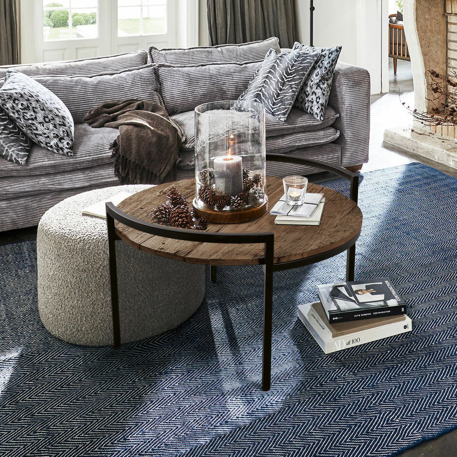 Table basse Rosemill Table basse ronde avec plateau en bois et cadre métallique sur tapis bleu dans un salon