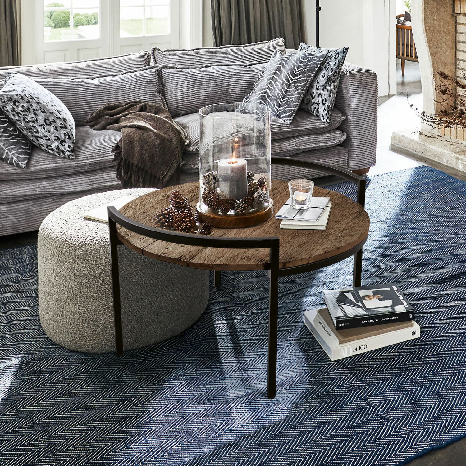 Table basse Rosemill Table basse ronde avec plateau en bois et cadre métallique sur tapis bleu dans un salon