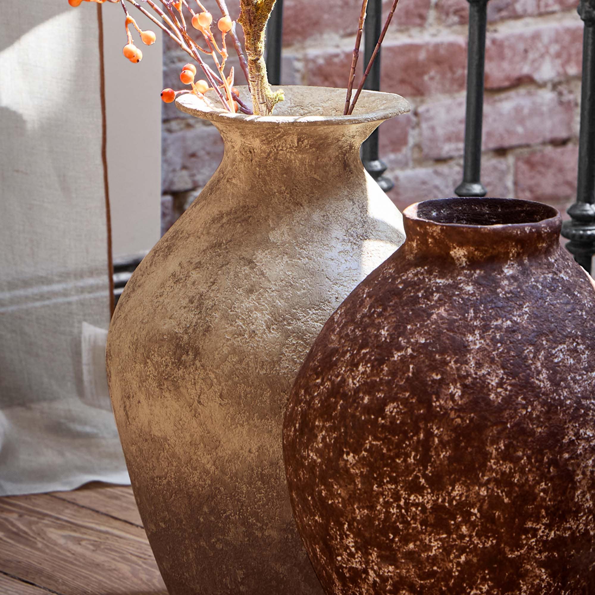Vases décoratifs en céramique beige et marron posés sur une table en bois rustique
