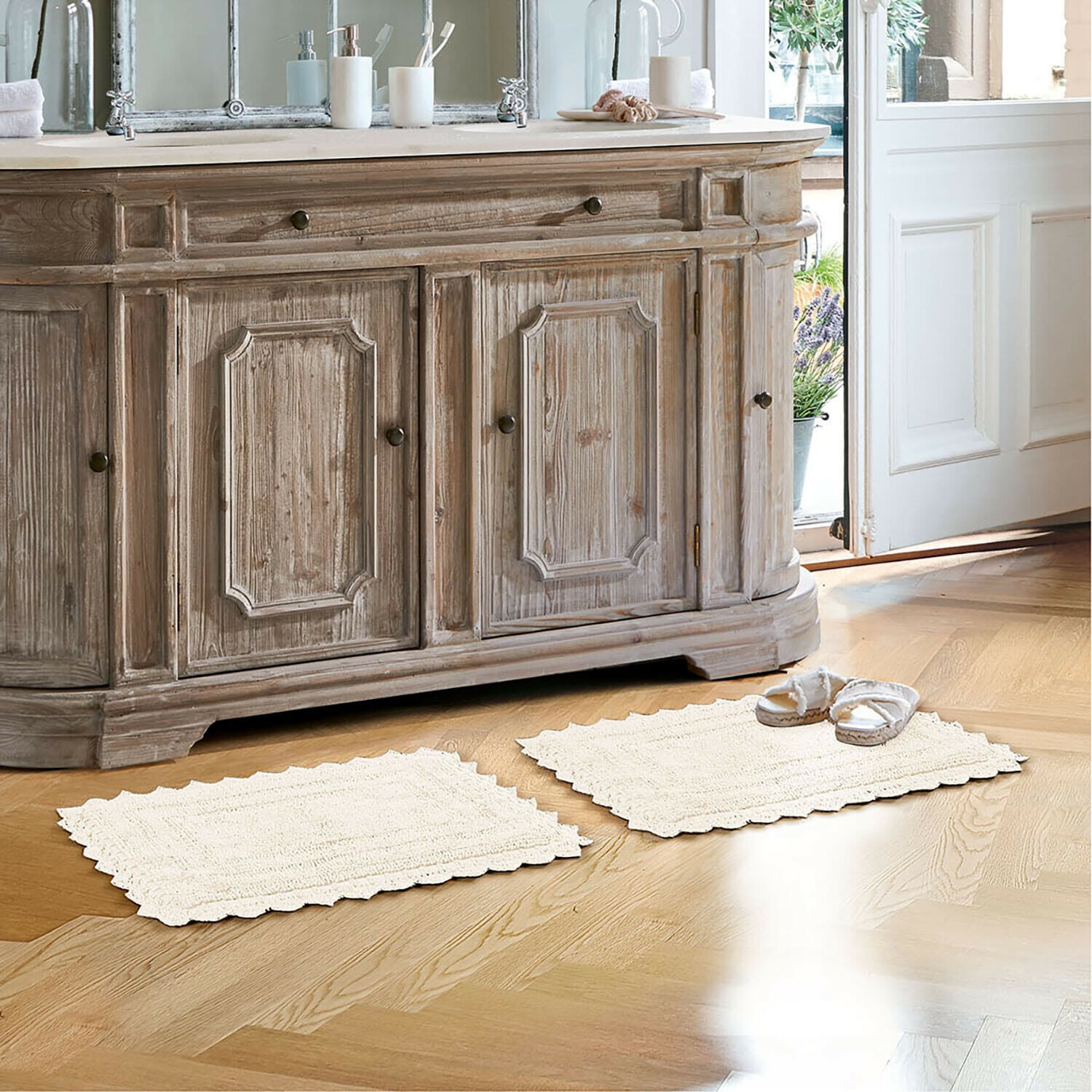 Tapis de bain Yalexir Meuble en bois style vintage avec deux tapis crème sur un sol clair dans une salle de bain lumineuse