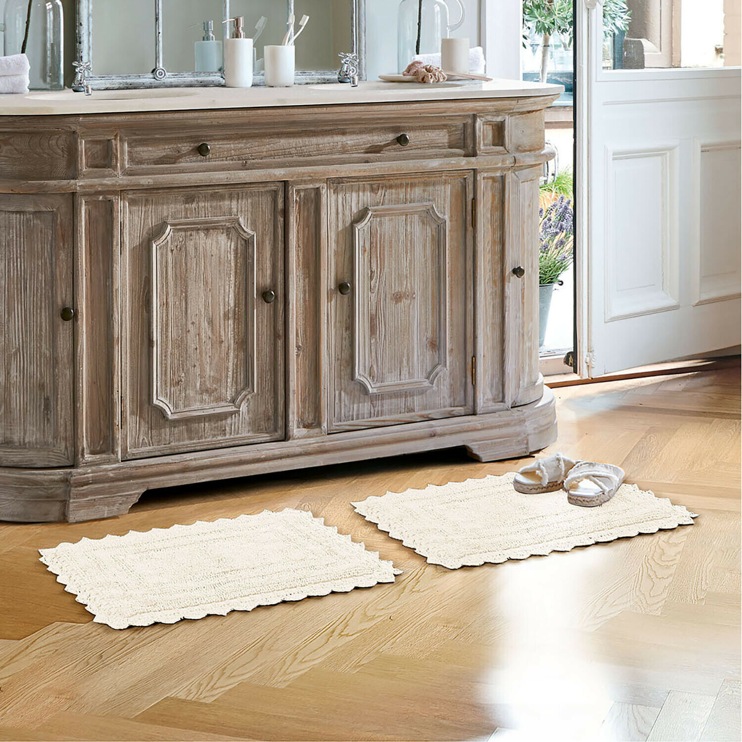 Tapis de bain Yalexir Meuble en bois style vintage avec deux tapis crème sur un sol clair dans une salle de bain lumineuse