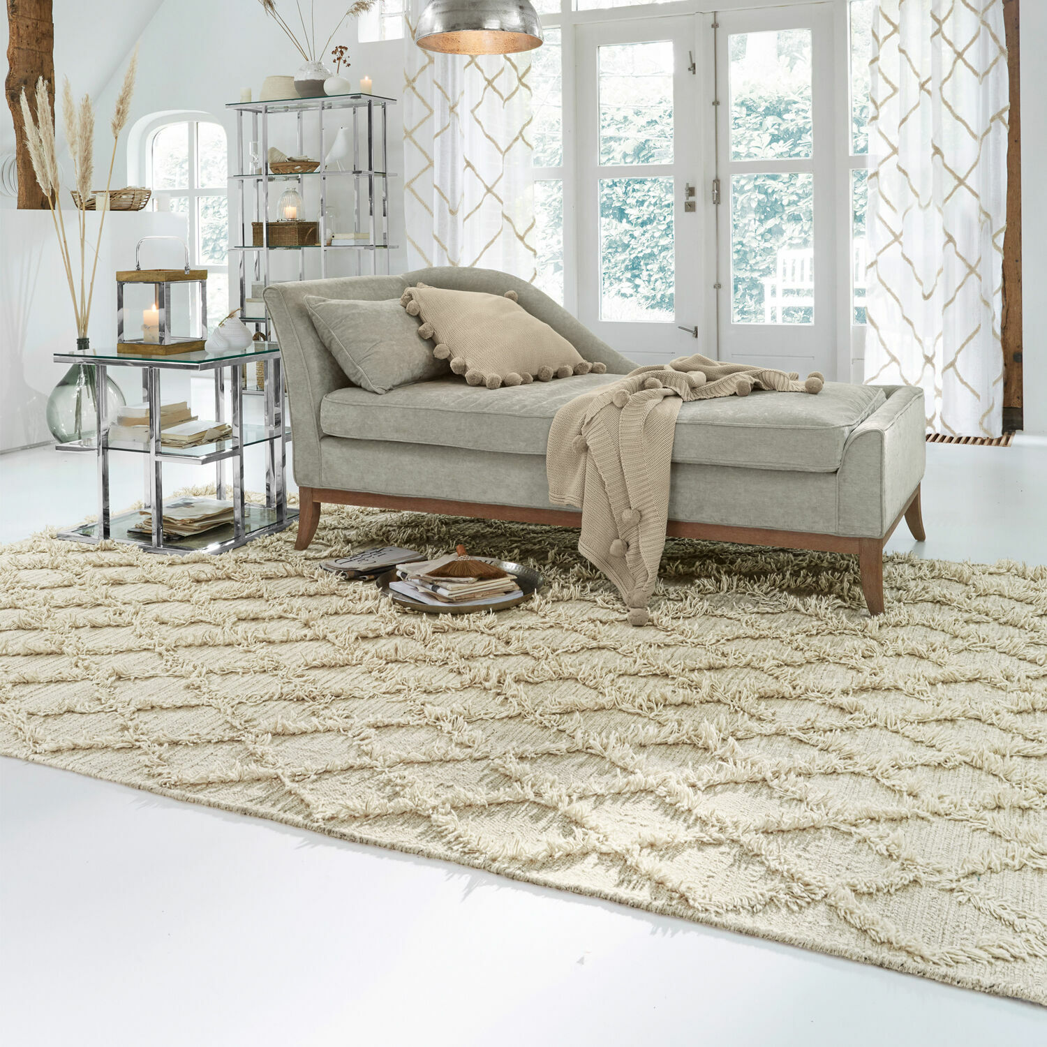 Tapis Yoann Chaise longue grise en tissu avec pieds en bois sur tapis beige dans un salon lumineux