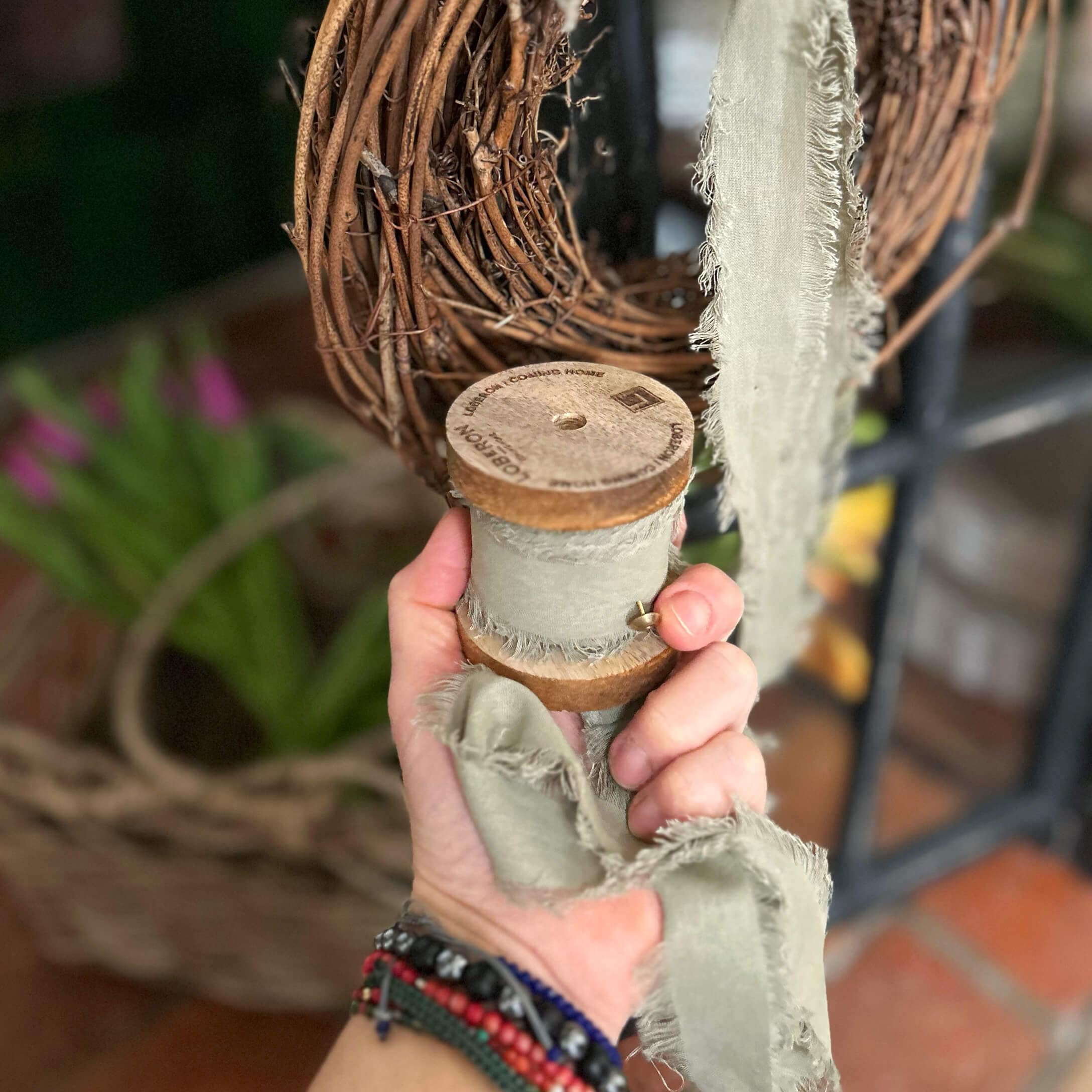 Ruban gris en coton avec bords effilochés sur bobine en bois pour décoration et artisanat