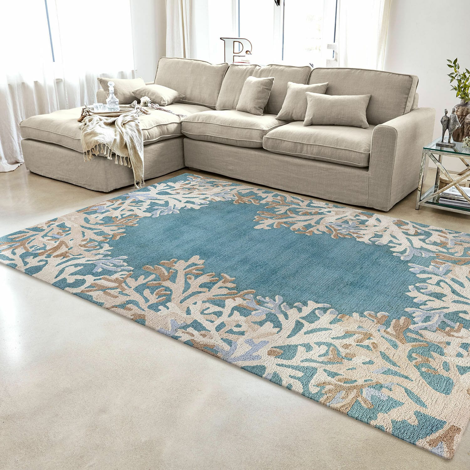 Tapis d’intérieur et d’extérieur Dorlancourt Tapis bleu et beige avec motif corail dans un salon moderne avec canapé beige et table en verre