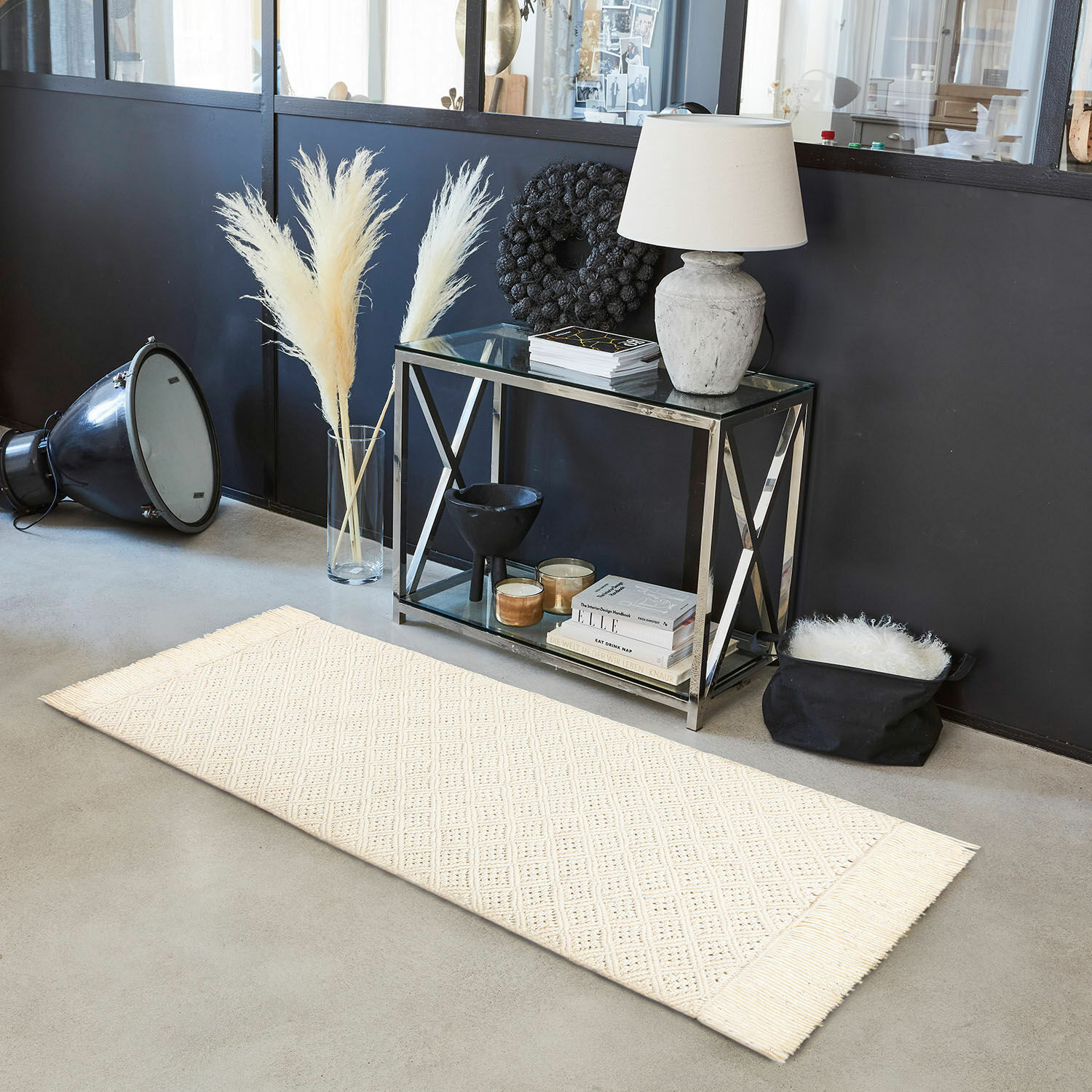 Tapis long Voué Tapis crème à franges avec motif géométrique sur sol en béton dans un intérieur moderne
