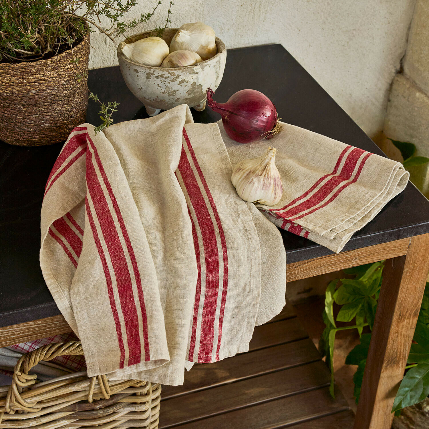 Lot de 2 torchons Norisse Torchon de cuisine en lin beige avec rayures rouges sur une table en bois au plateau noir