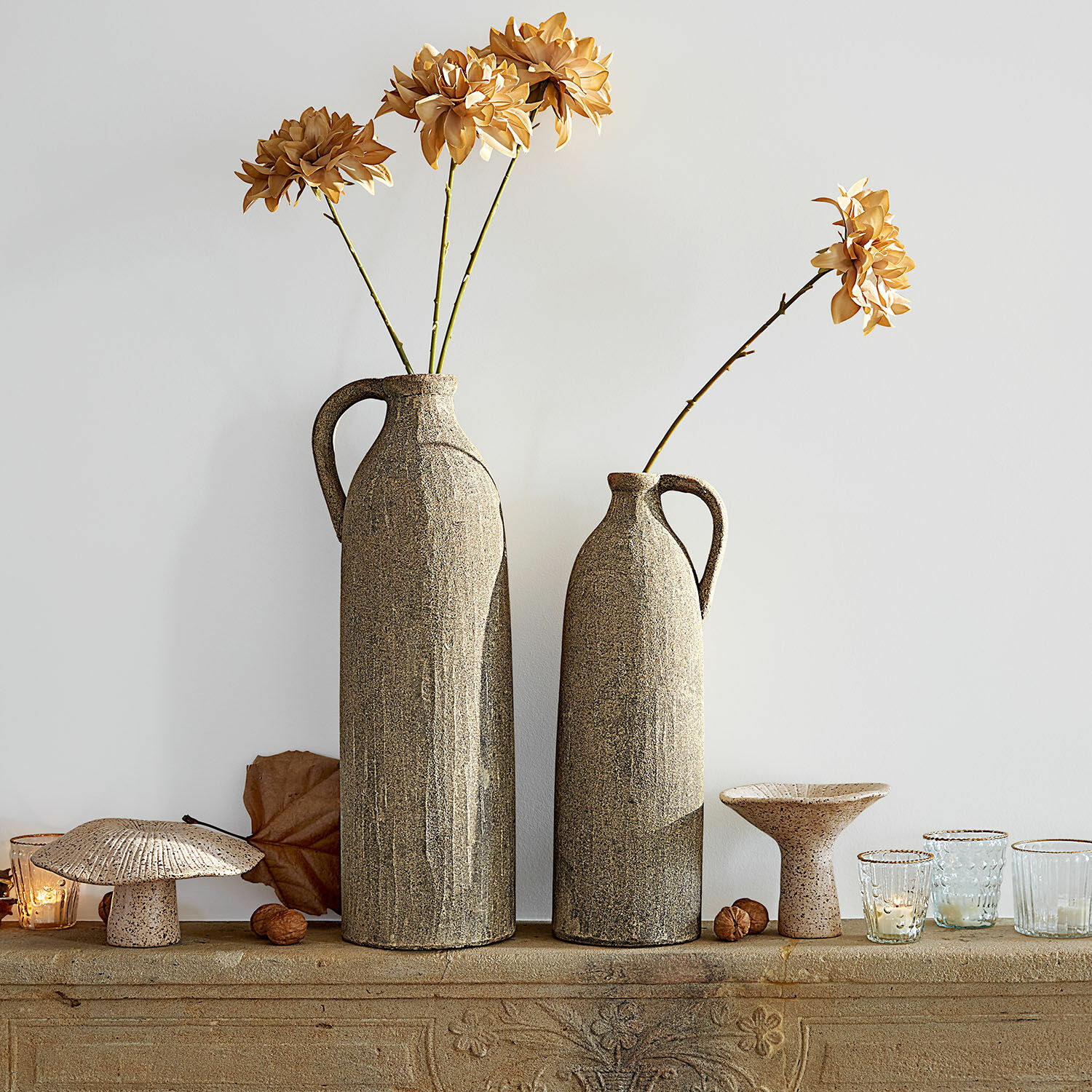 Lot de 2 vases Kalidaan Deux grands vases en céramique beige avec fleurs séchées et décorations sur une surface en pierre