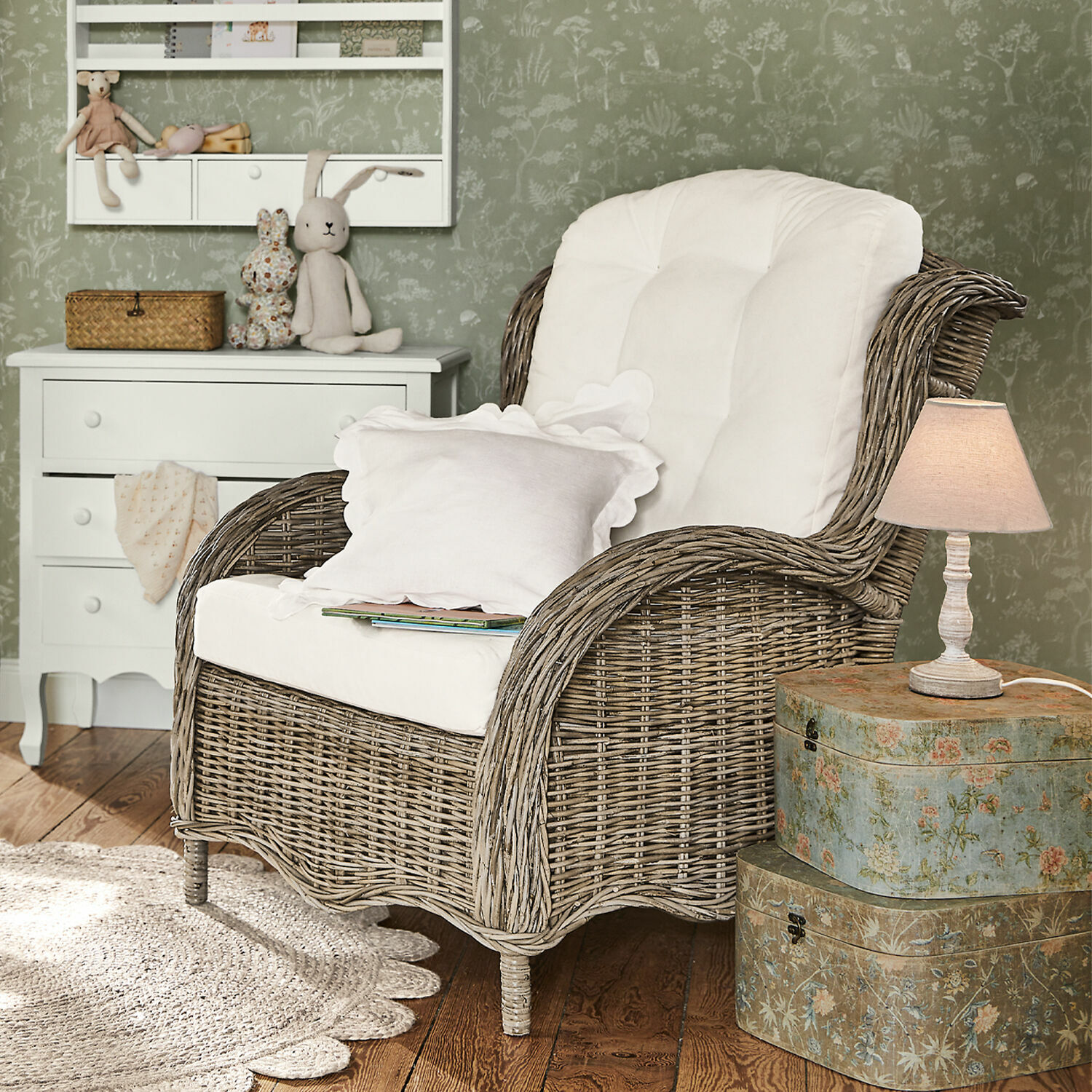 Fauteuil Hailee Fauteuil en osier avec coussin blanc dans un intérieur cosy avec lampe et commode décorative