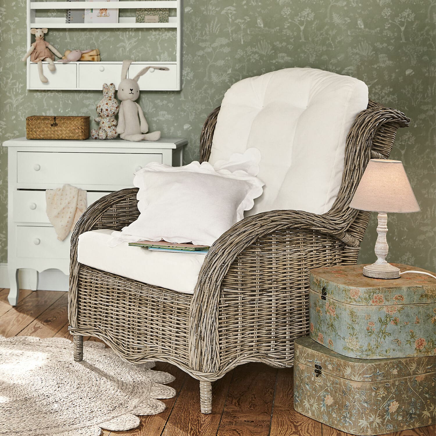 Fauteuil Hailee Fauteuil en osier avec coussin blanc dans un intérieur cosy avec lampe et commode décorative