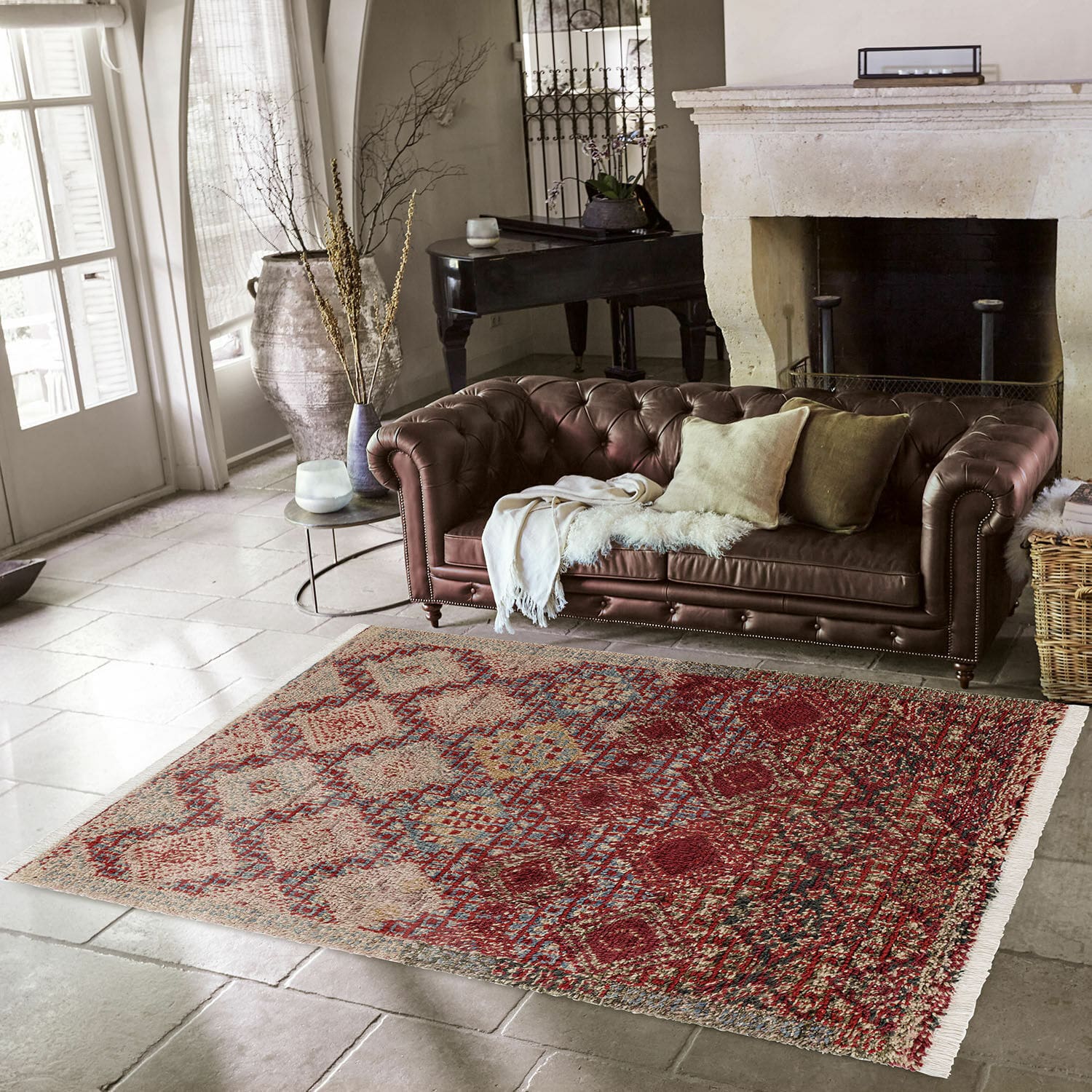 Tapis Thalivine Tapis à motif géométrique rouge et beige sur sol en pierre dans un salon avec canapé en cuir marron