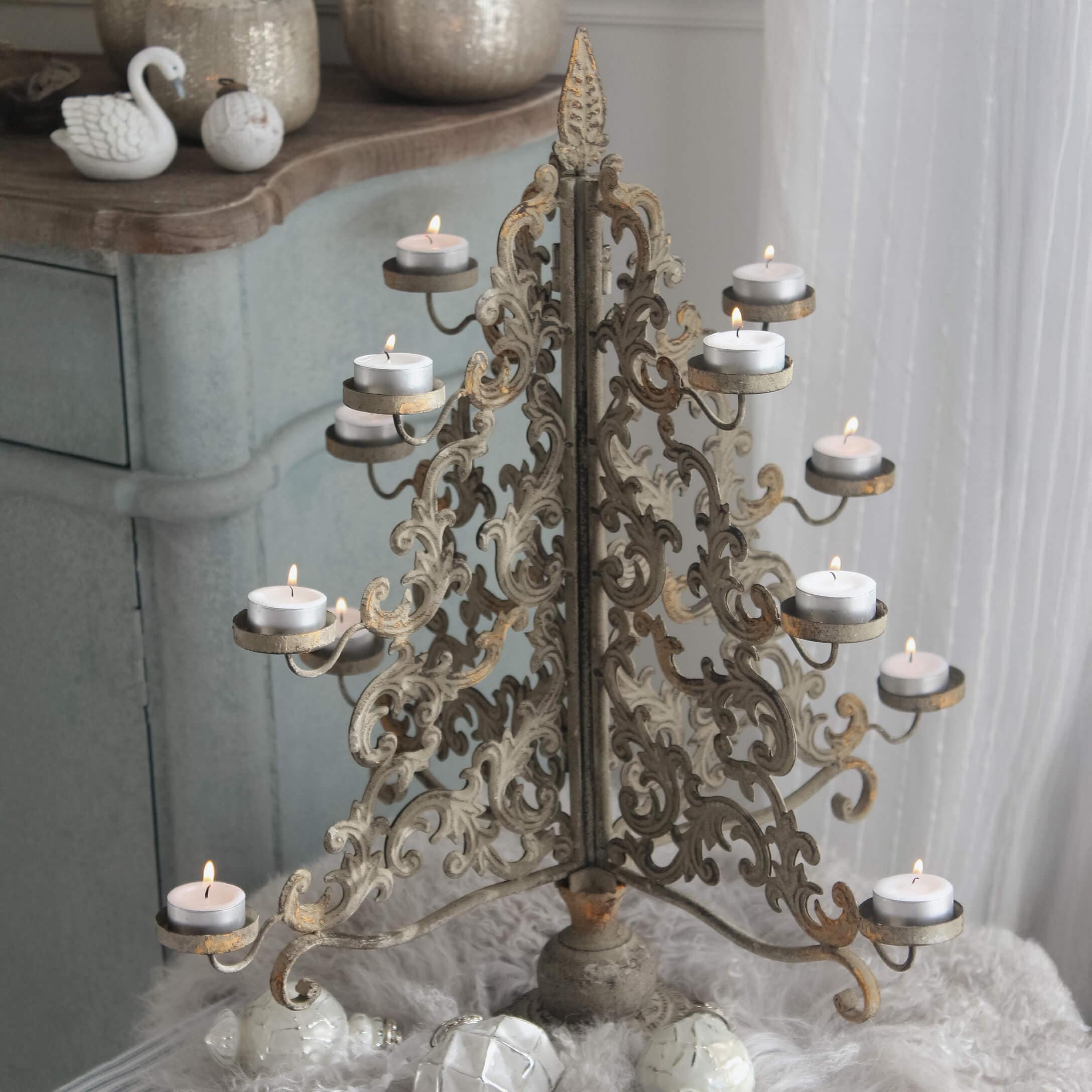 Chandelier en métal doré vieilli avec motifs ajourés et bougies chauffe-plat allumées