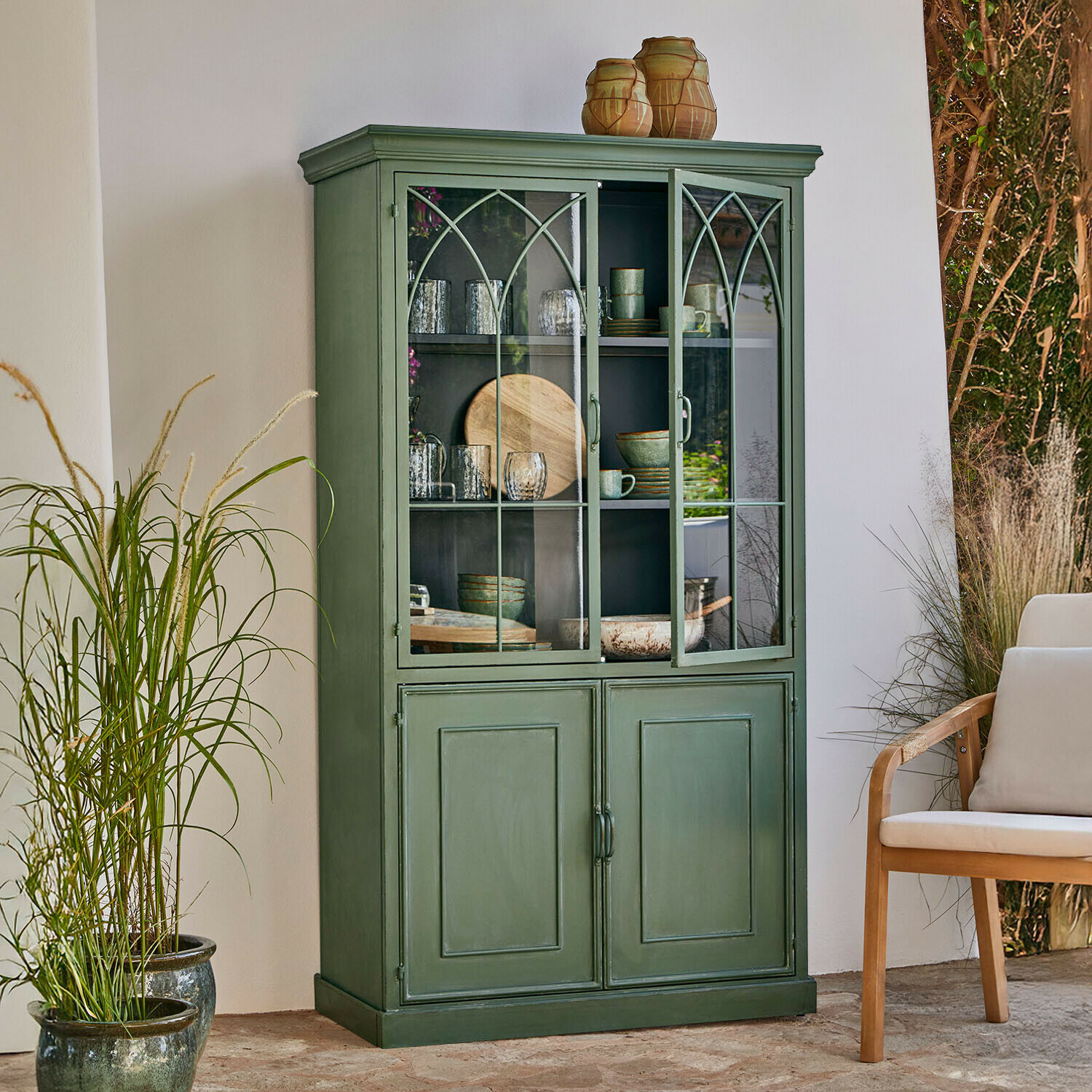 Vitrine en bois vert avec portes vitrées et étagères pour vaisselle dans un style vintage