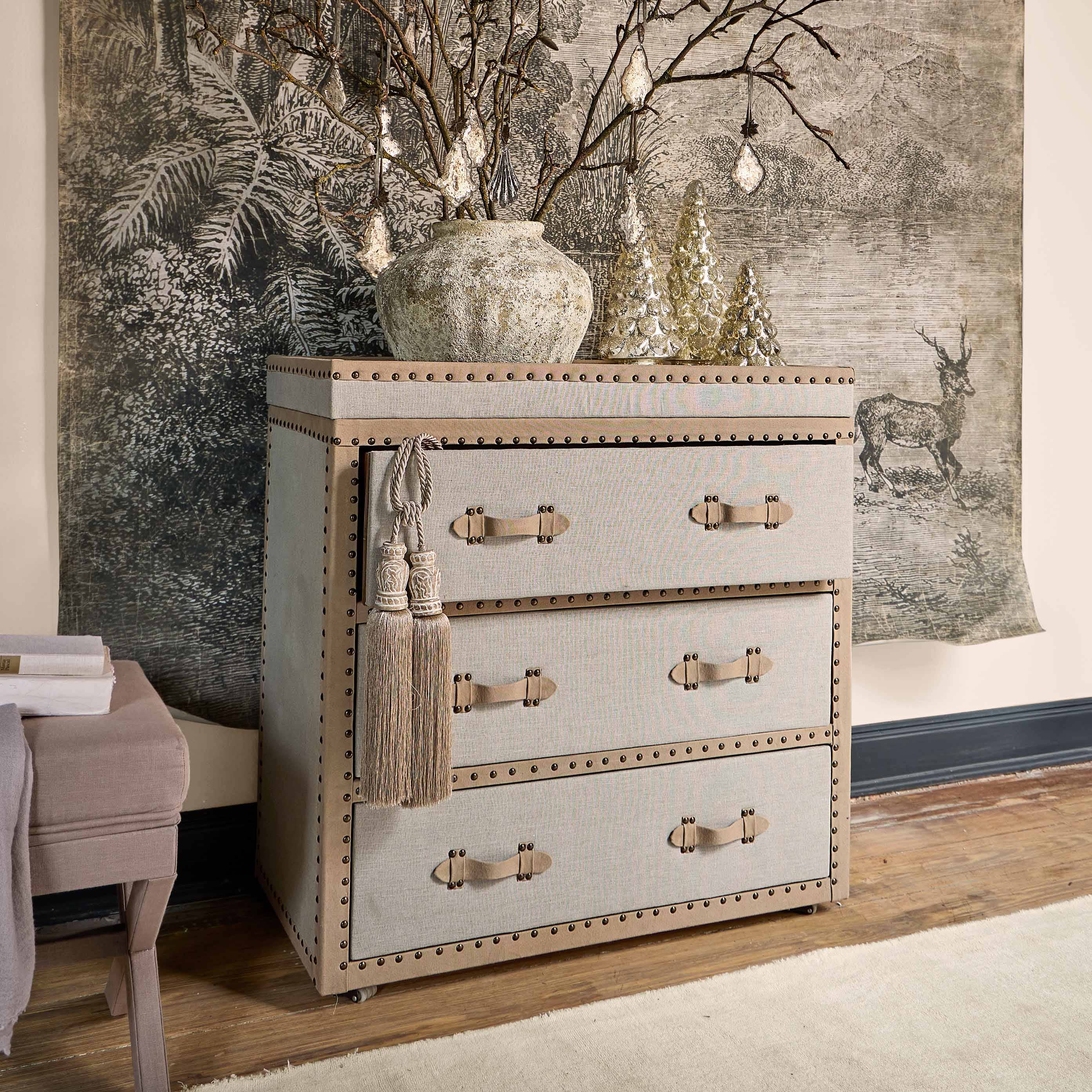 Commode beige en tissu avec poignées décoratives et pampilles, style vintage pour salon