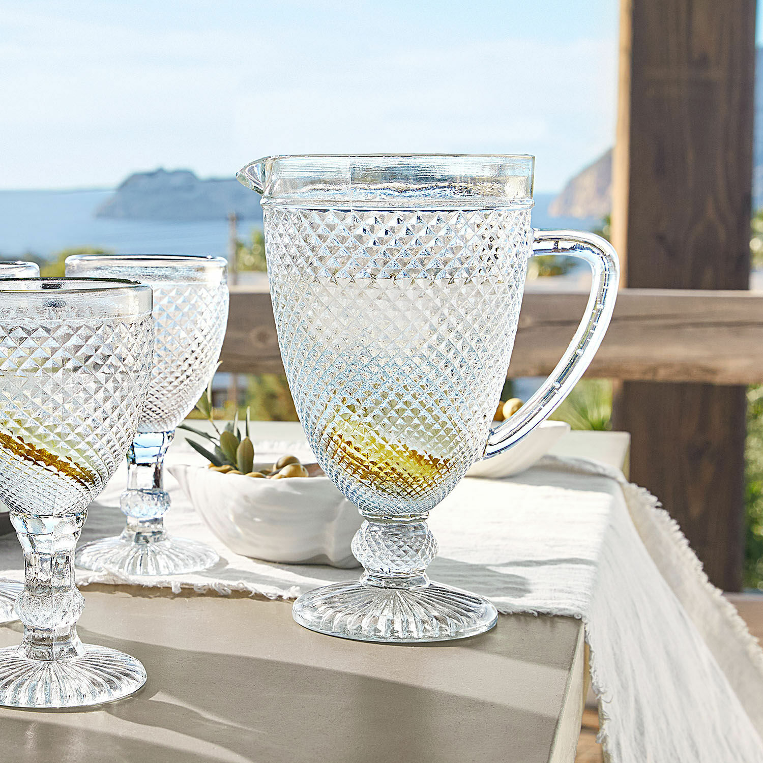 Pichet Santerre Pichet et verres transparents en verre texturé sur une table avec vue sur la mer