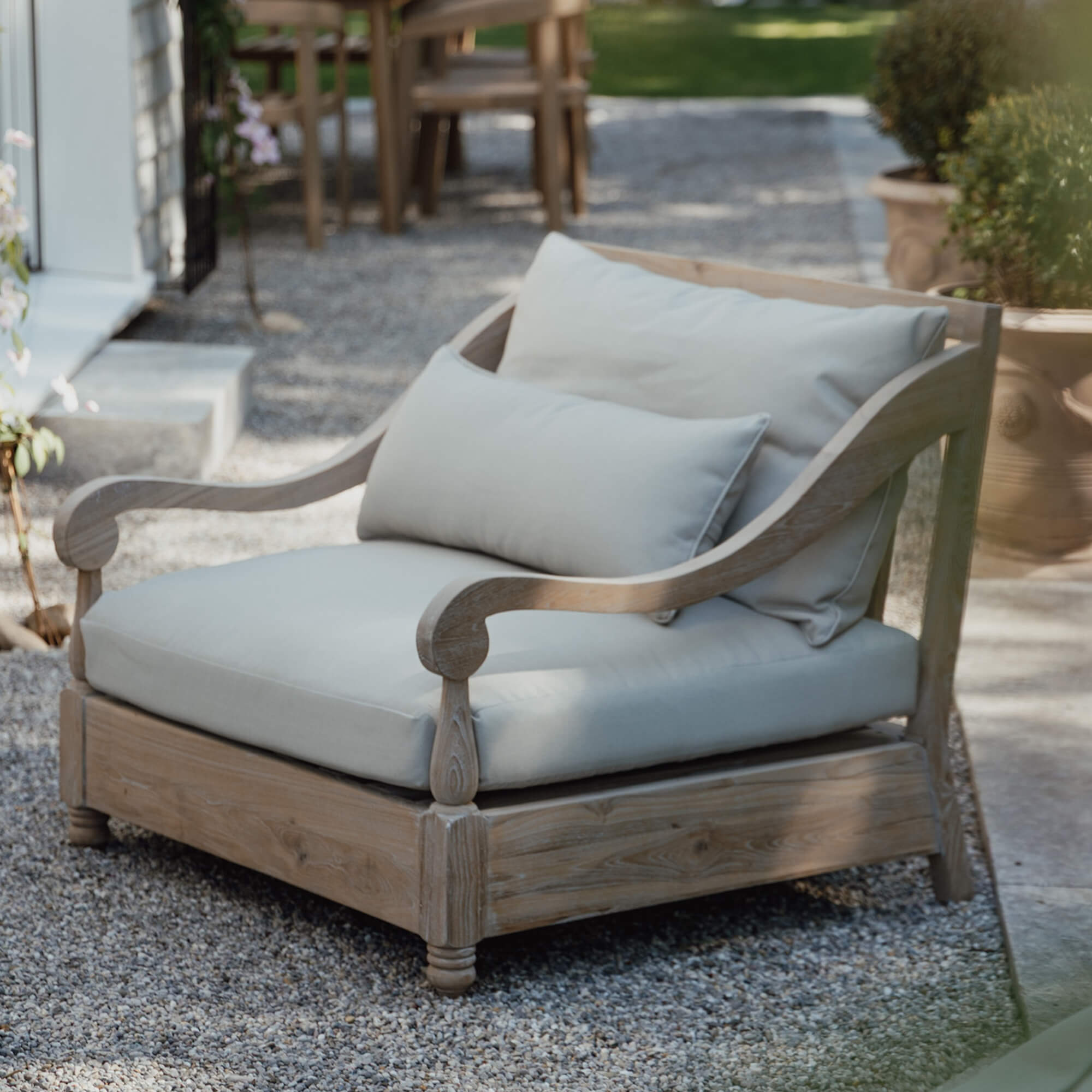 Fauteuil de jardin en bois clair avec coussins crème, mobilier confortable pour terrasse