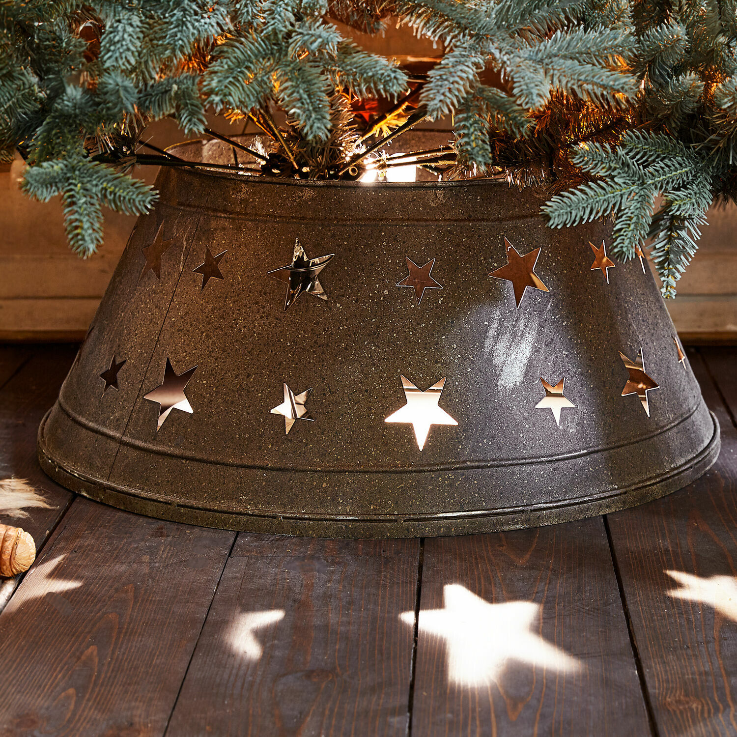 Cache-pied pour sapin de Noël Ysabelle Cache-pied d'arbre en métal gris foncé avec découpes en forme d'étoiles, décoration de Noël sur plancher en bois
