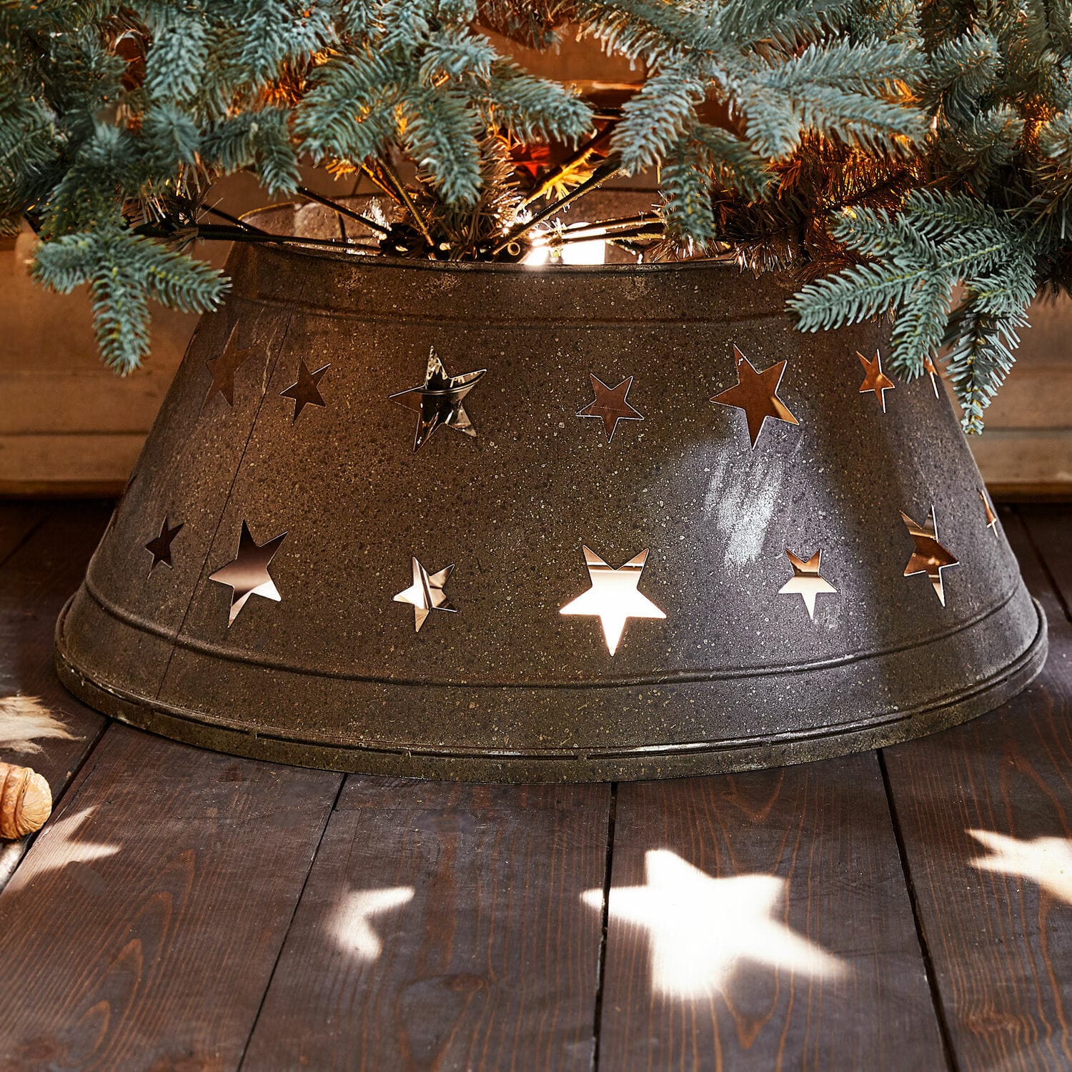 Cache-pied pour sapin de Noël Ysabelle Cache-pied d'arbre en métal gris foncé avec découpes en forme d'étoiles, décoration de Noël sur plancher en bois