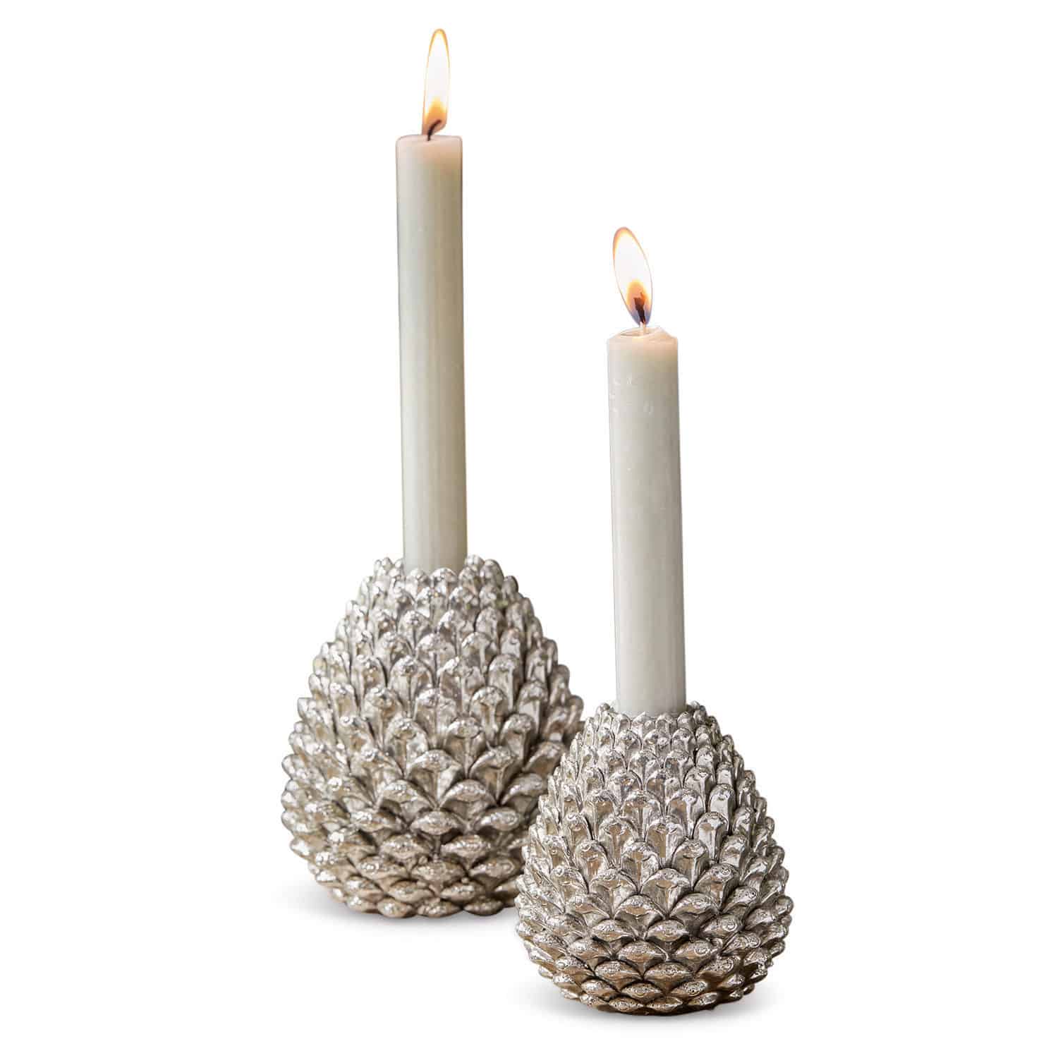 Lot de 2 porte-bougies Mirbells Deux bougeoirs argentés en forme de pomme de pin avec bougies blanches allumées, décoration élégante