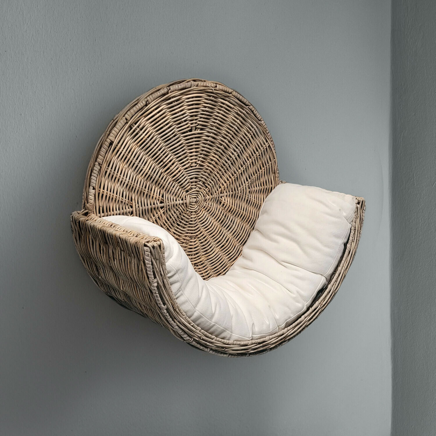Fauteuil suspendu en rotin avec coussin blanc moelleux sur fond gris, meuble moderne pour détente