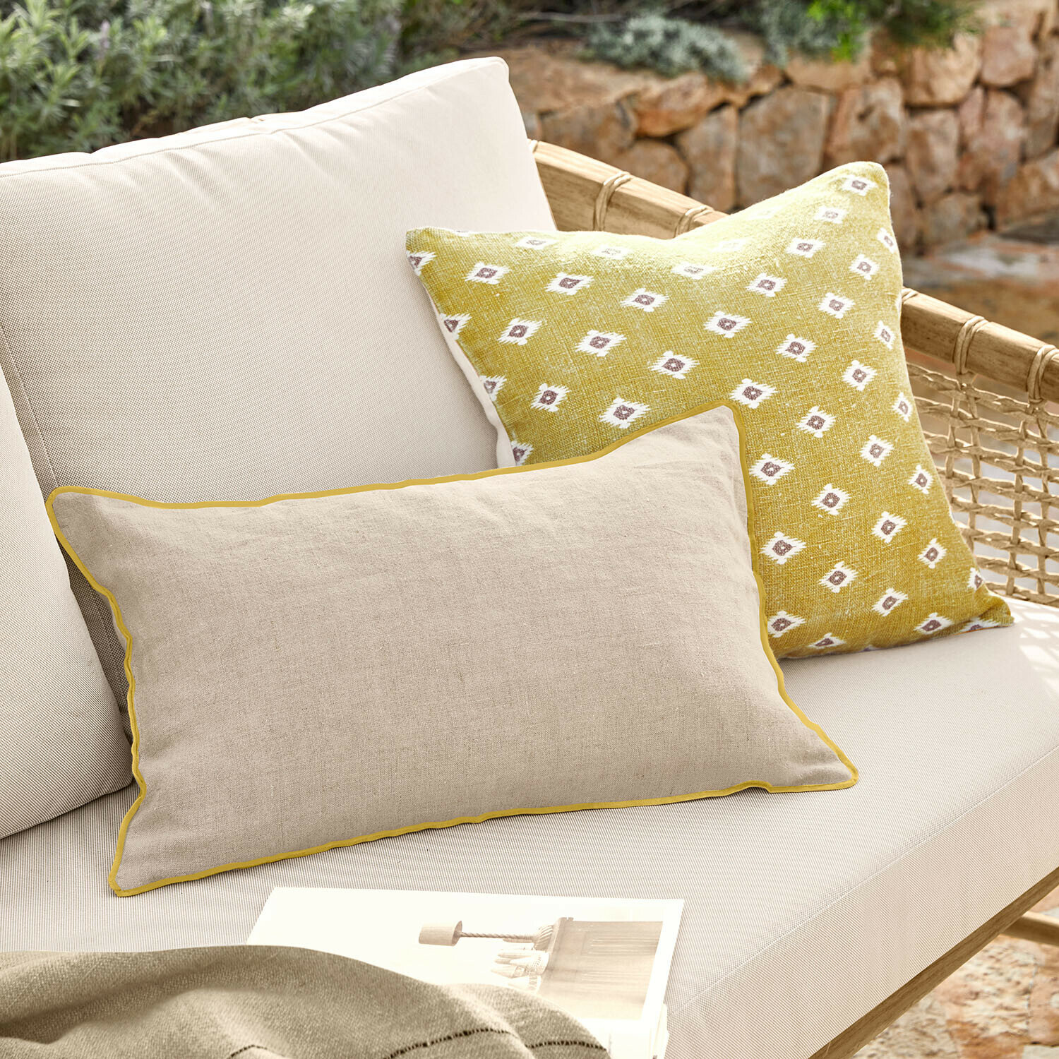 Lot de 2 housses de coussins Brisalda Coussin beige en lin avec bordure jaune et coussin jaune à motif blanc sur canapé d'extérieur clair
