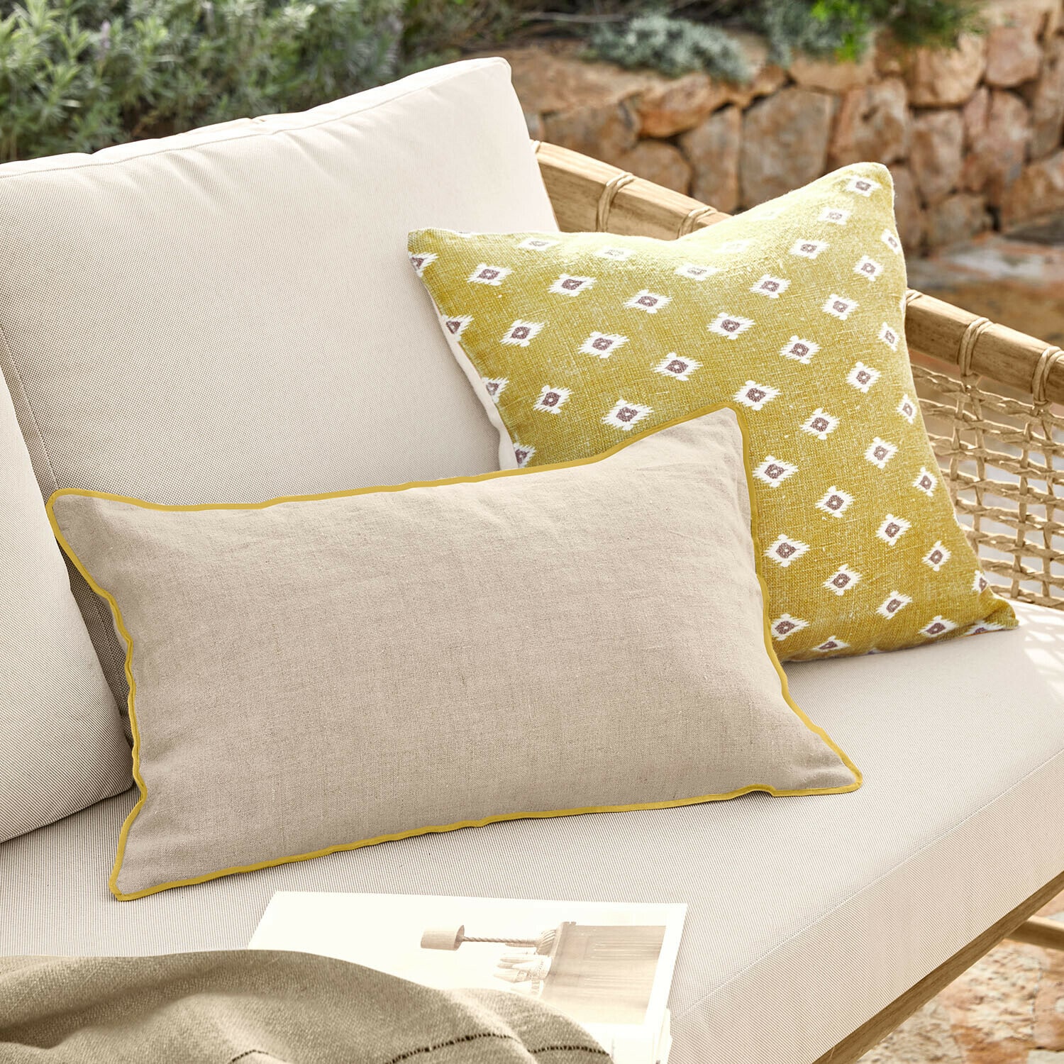Lot de 2 housses de coussins Brisalda Coussin beige en lin avec bordure jaune et coussin jaune à motif blanc sur canapé d'extérieur clair