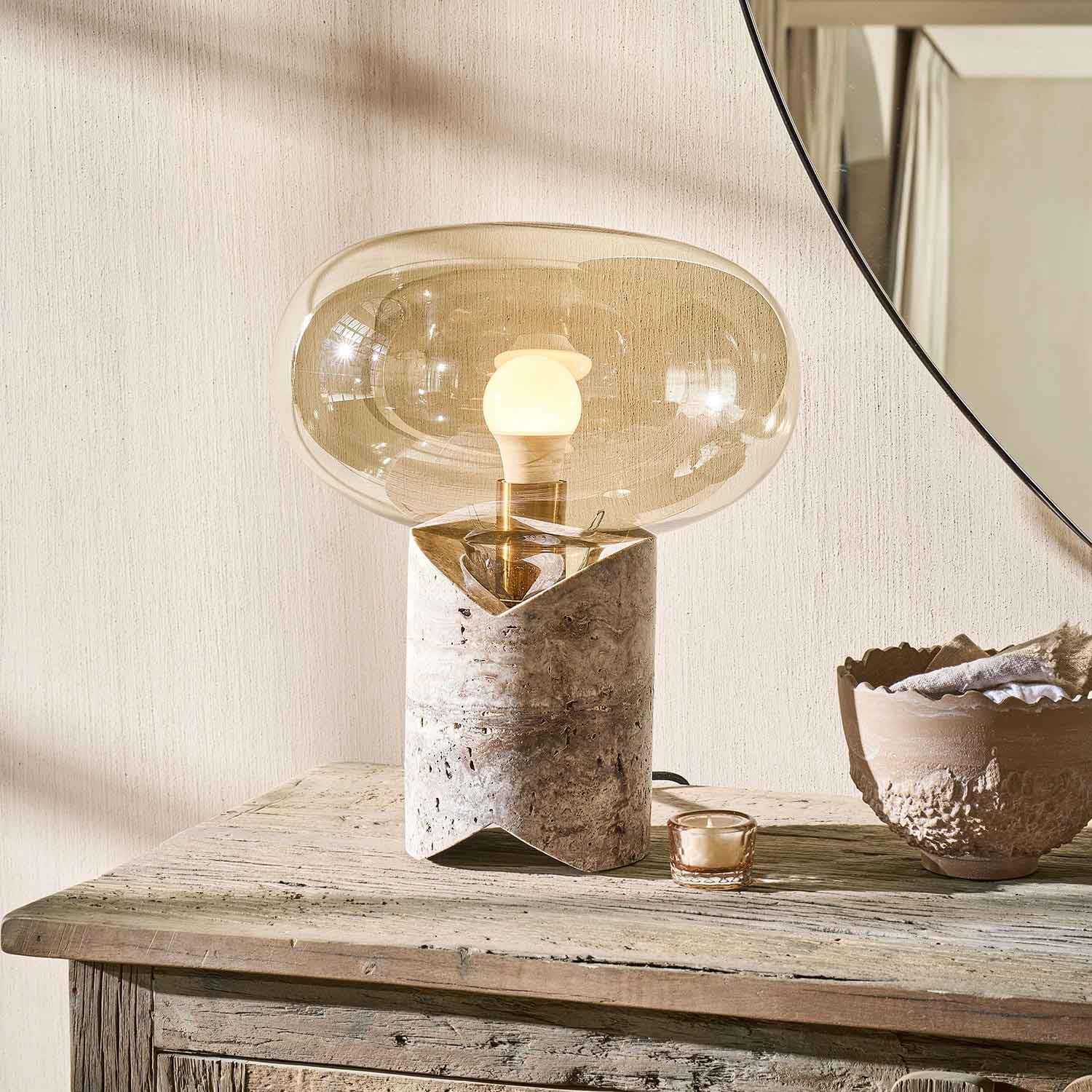 Lampe de table avec base en marbre et abat-jour en verre transparent beige sur meuble en bois