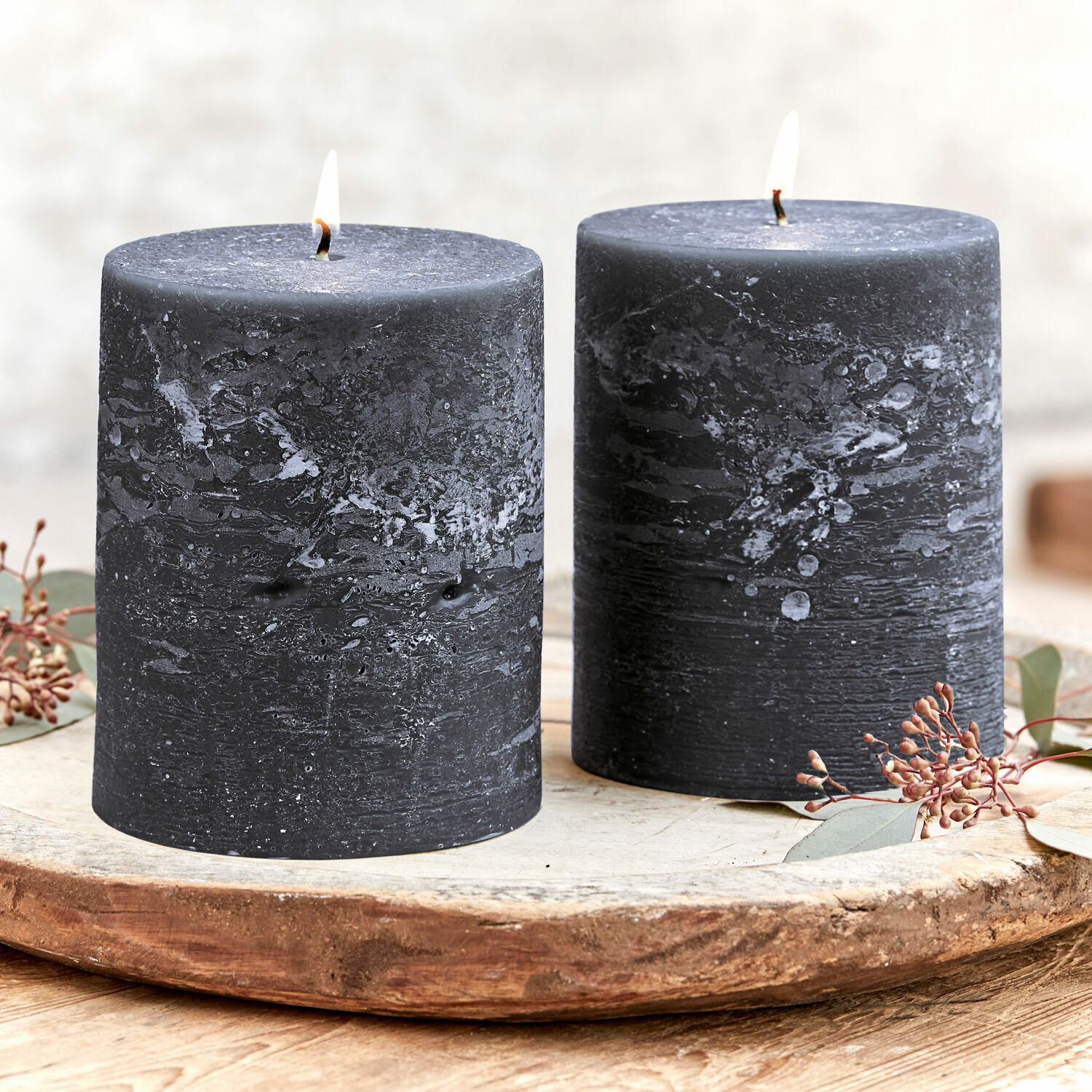 Lot de 2 bougies Oviedo Deux bougies noires en cire texturée sur un plateau en bois décoratif