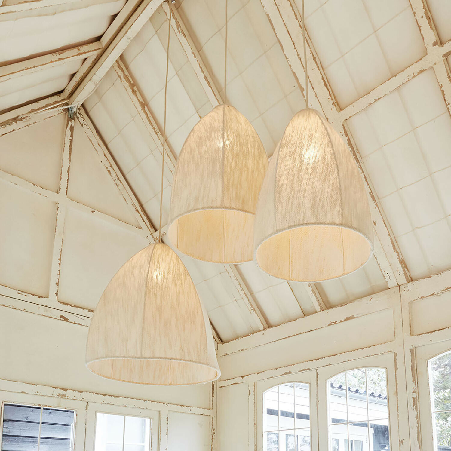 Lot de 3 suspensions Reveaux Trois suspensions en tissu clair en forme de cloche dans un intérieur rustique avec plafond blanc