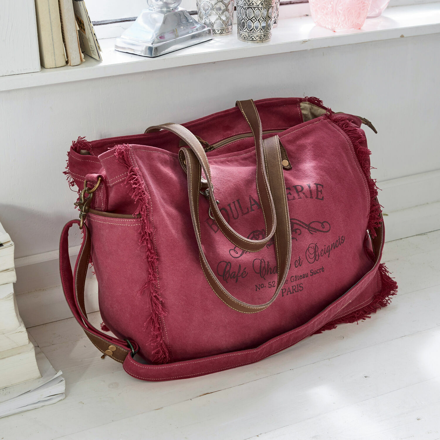 Sac Anoush Sac de voyage en toile rouge avec poignées marron et impression vintage posé sur un sol blanc