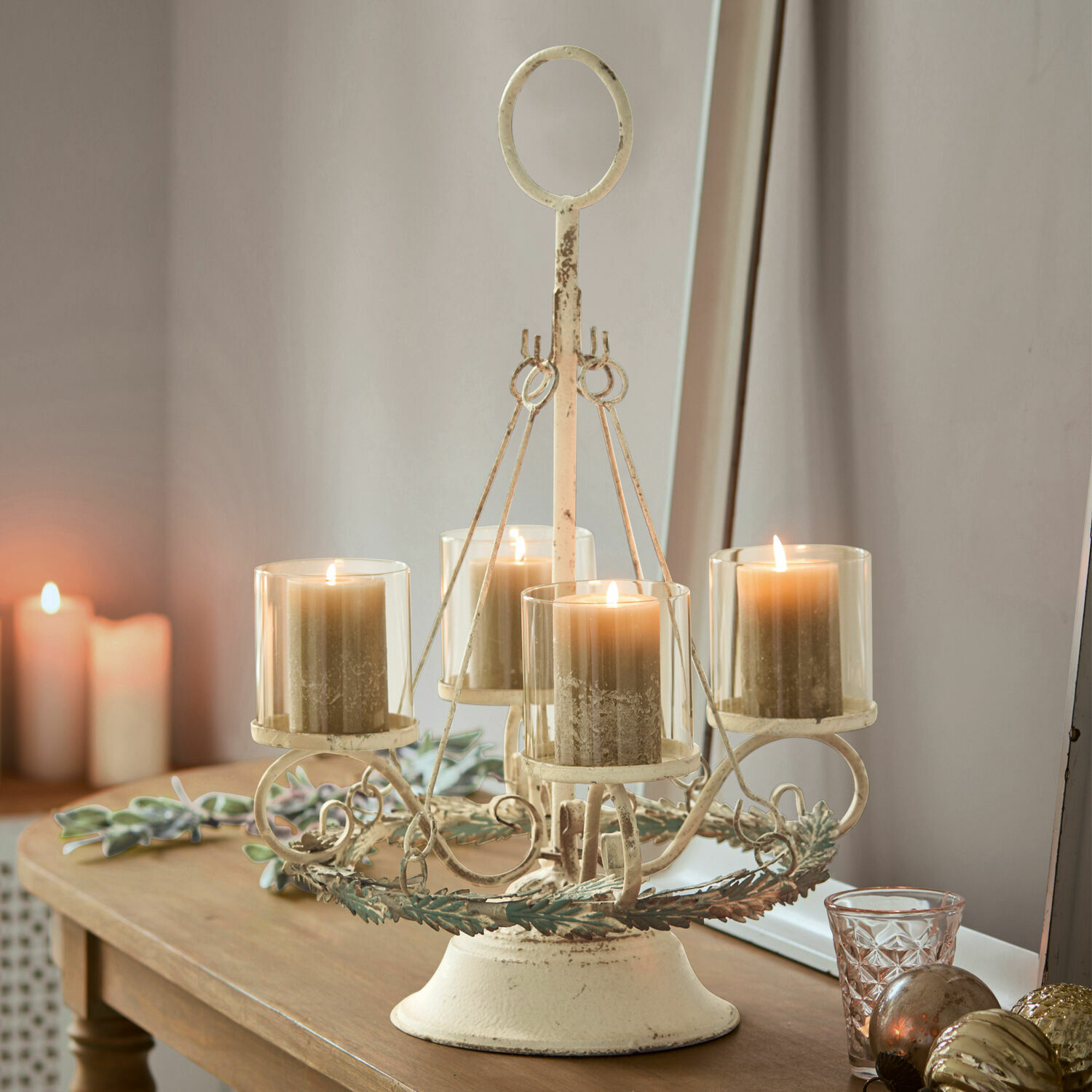Support pour couronne de l'Avent Denders Chandelier en métal vintage crème avec quatre bougies beiges sur une table en bois, décoration intérieure
