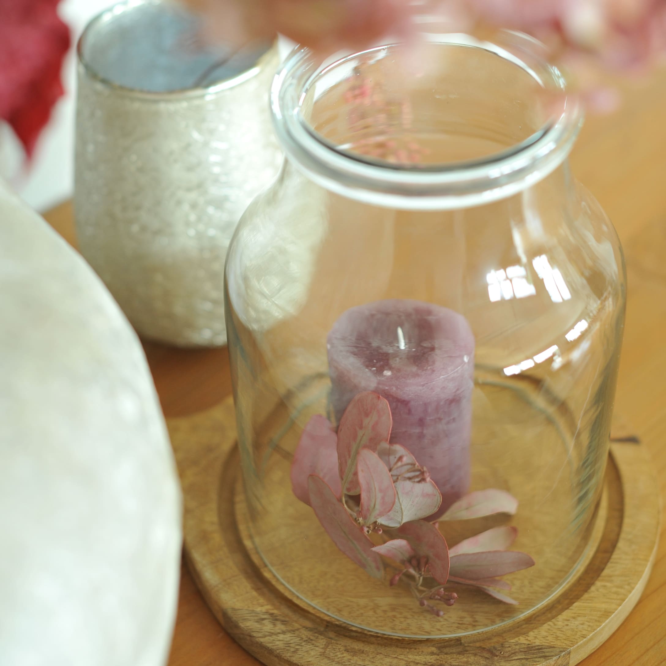 Vase Champs en verre transparent sur socle en bois avec bougie violette et feuilles séchées décoratives