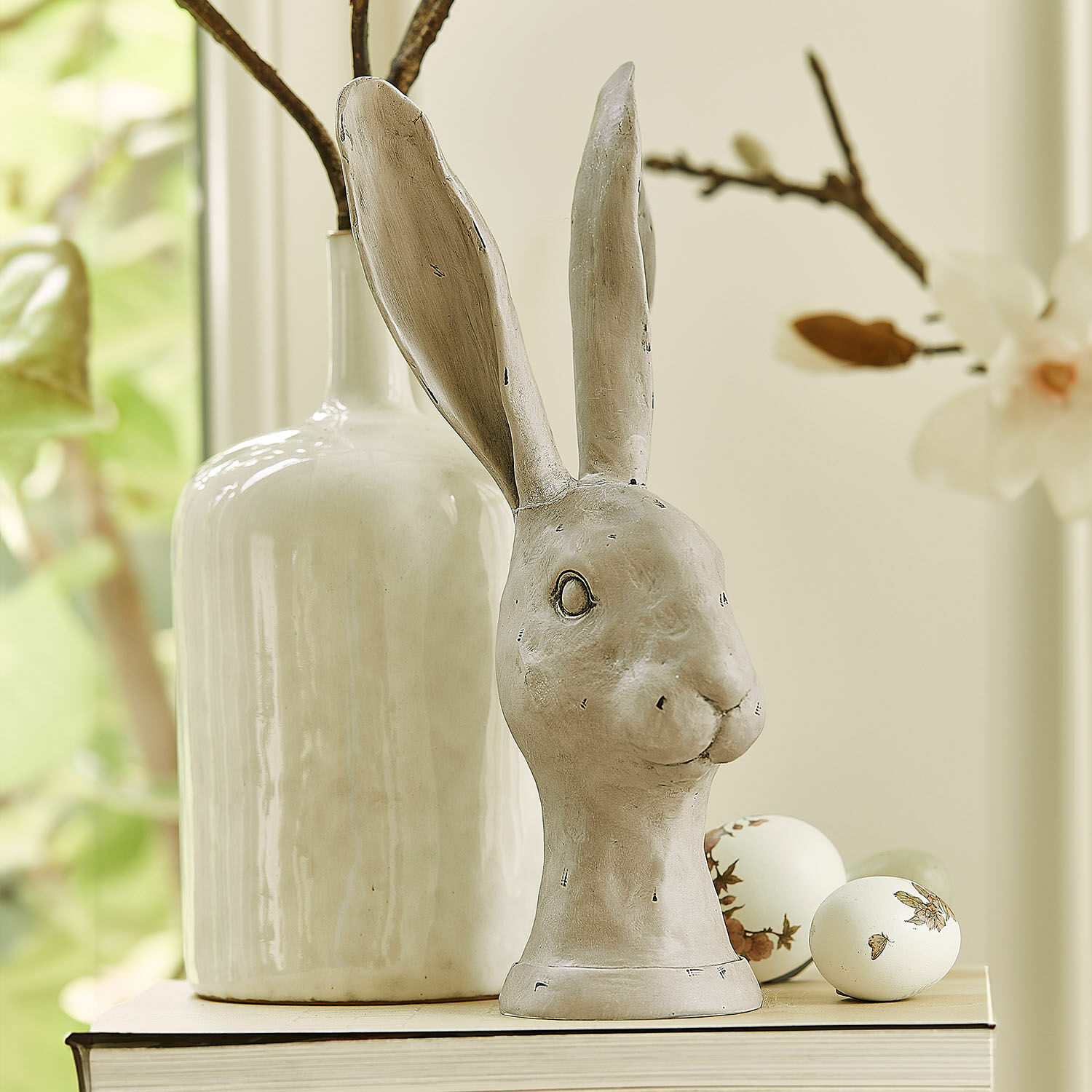 Lapin Najirah Figurine décorative de lapin en céramique grise posée sur un livre avec des œufs décoratifs